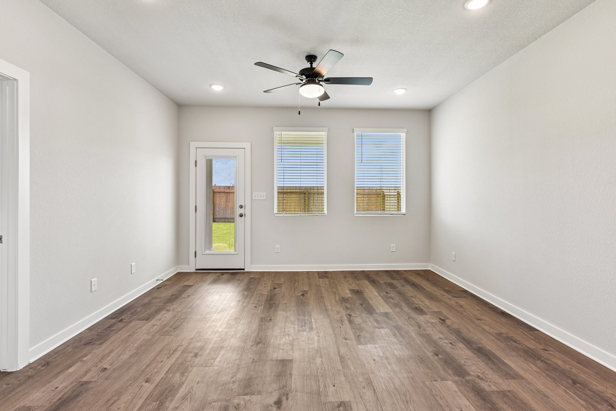 A room with a wood floor and a ceiling fan.
