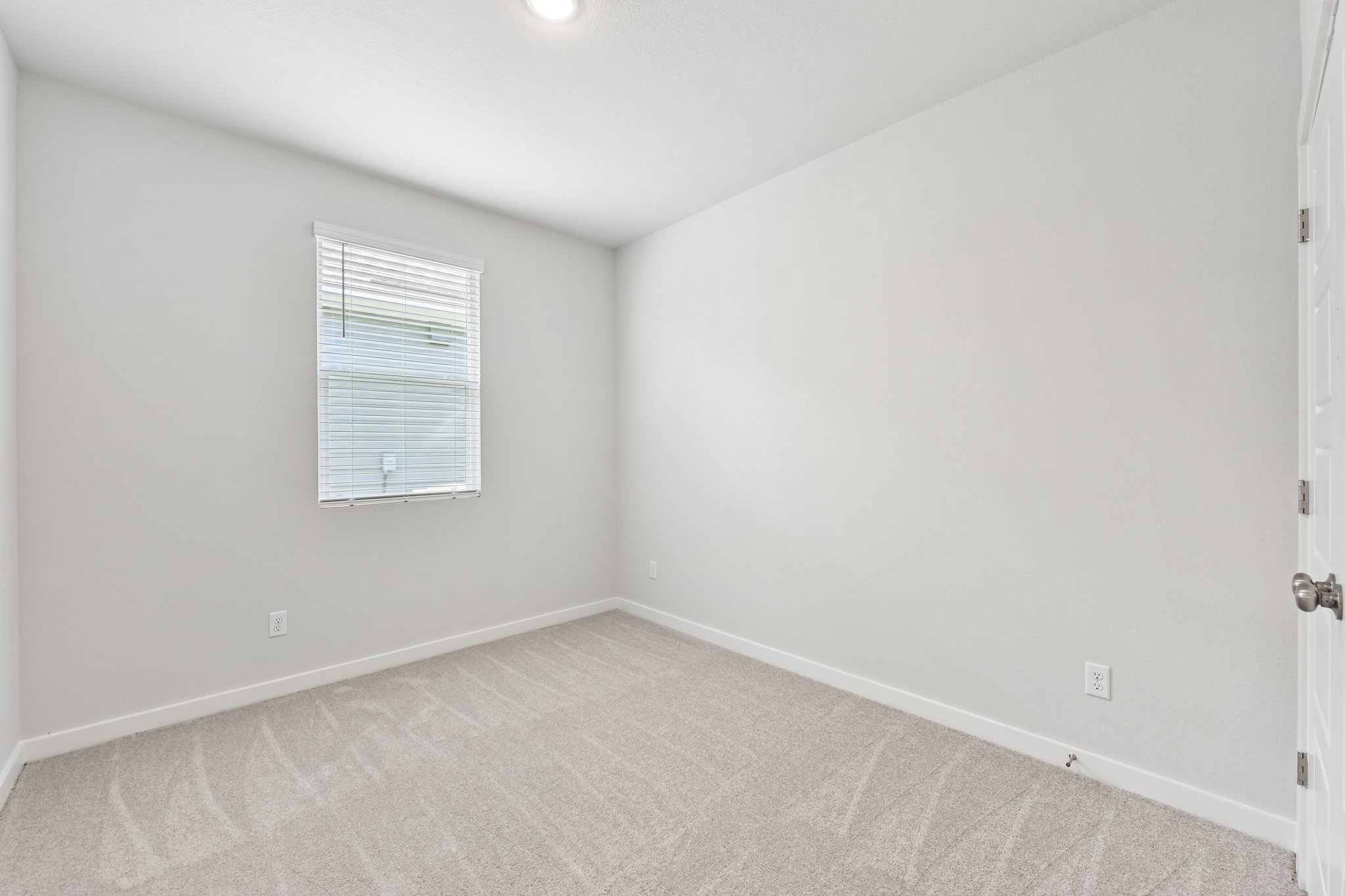 A room with a carpet and a window.