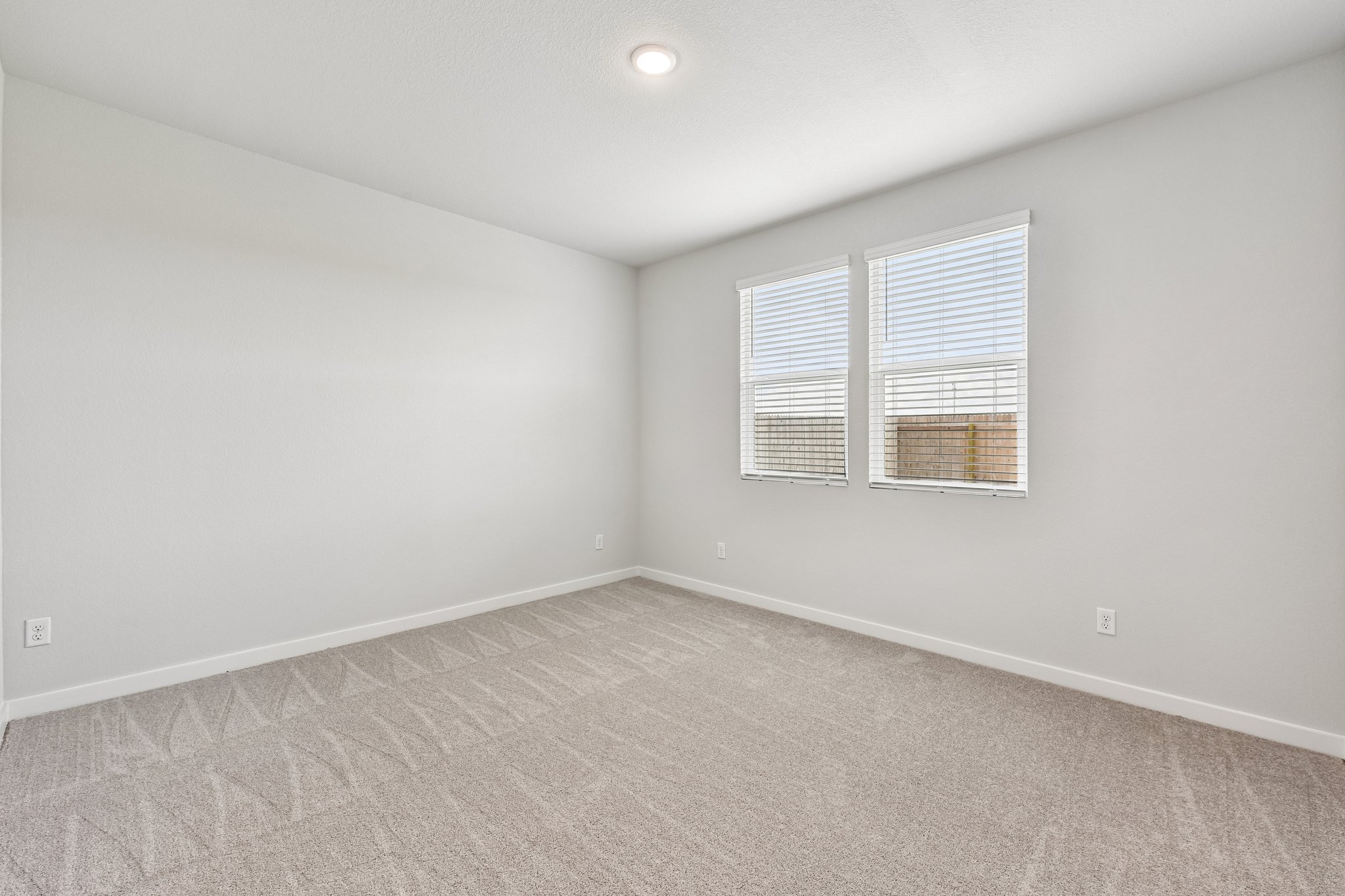 A room with a window and carpet.