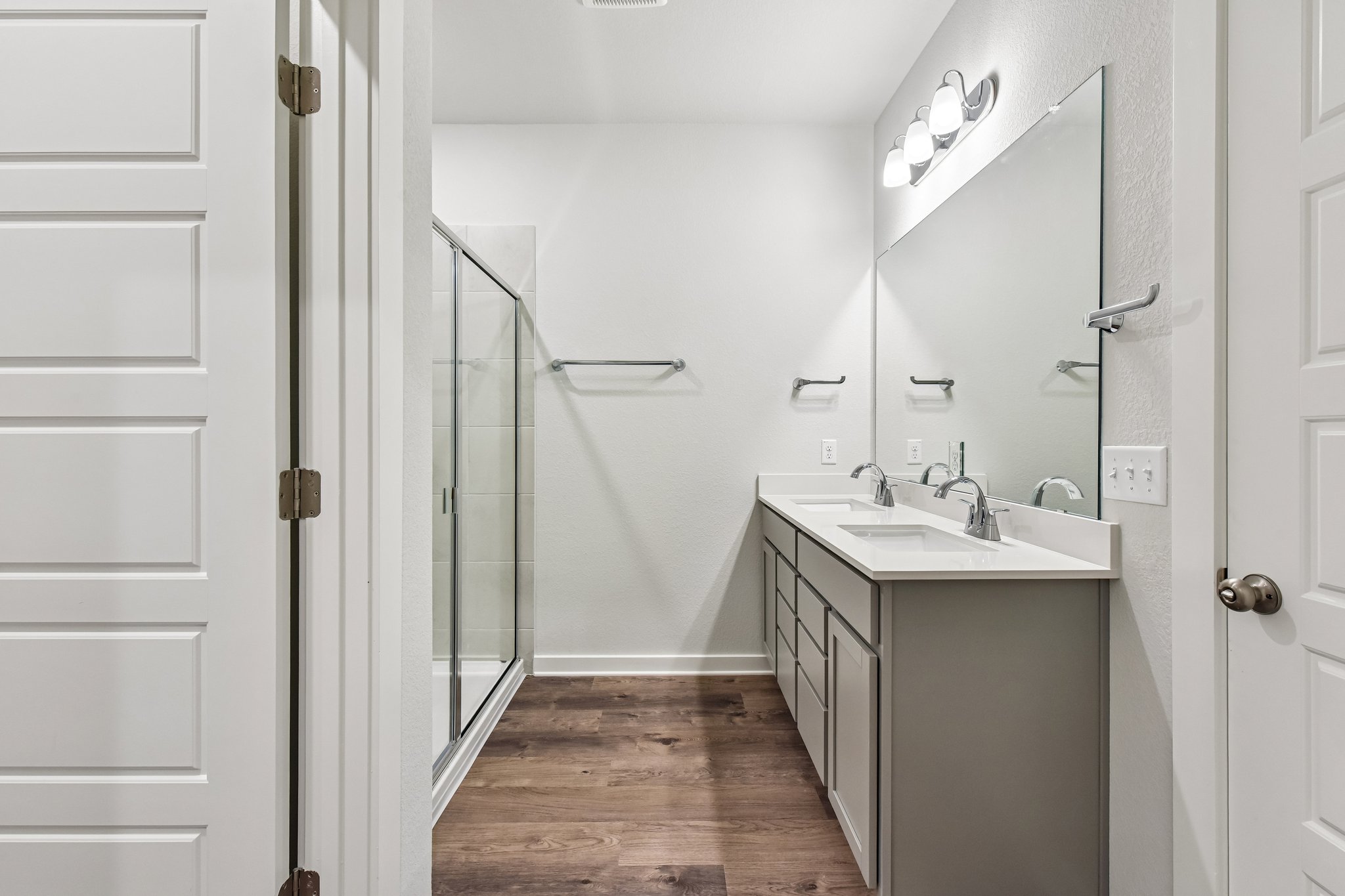 A bathroom with a sink and a shower unit.