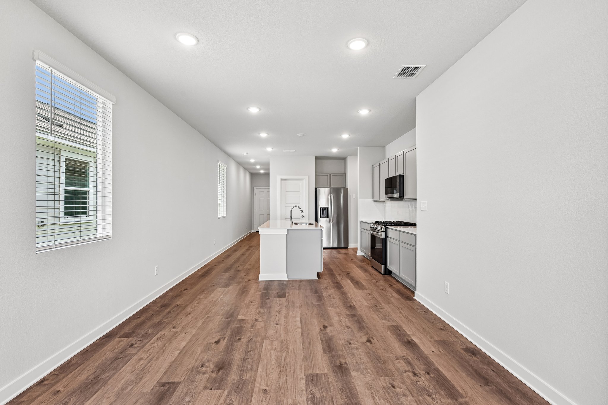 A large white room with a wood floor and white walls.