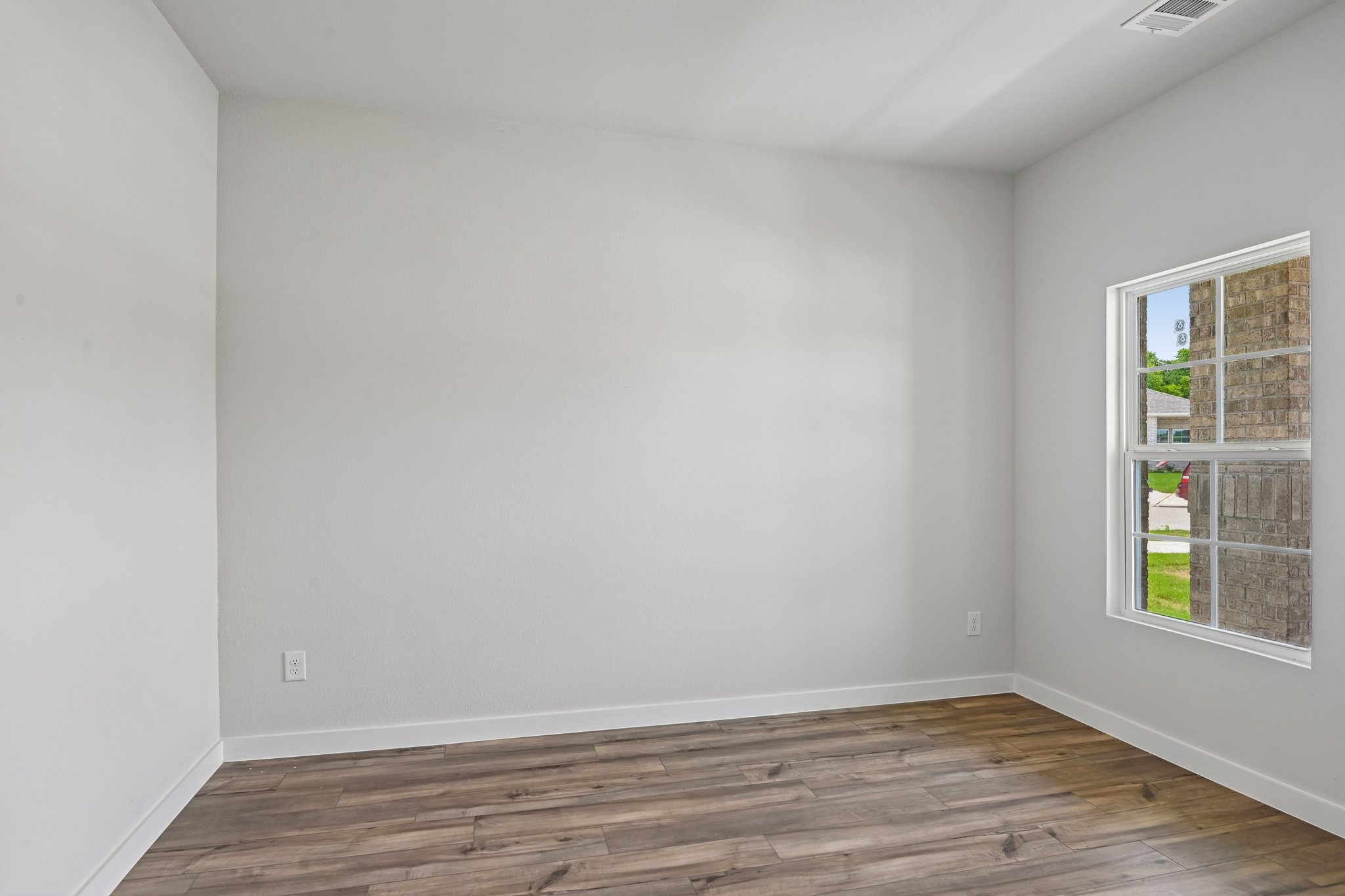 A room with a wood floor and a window.