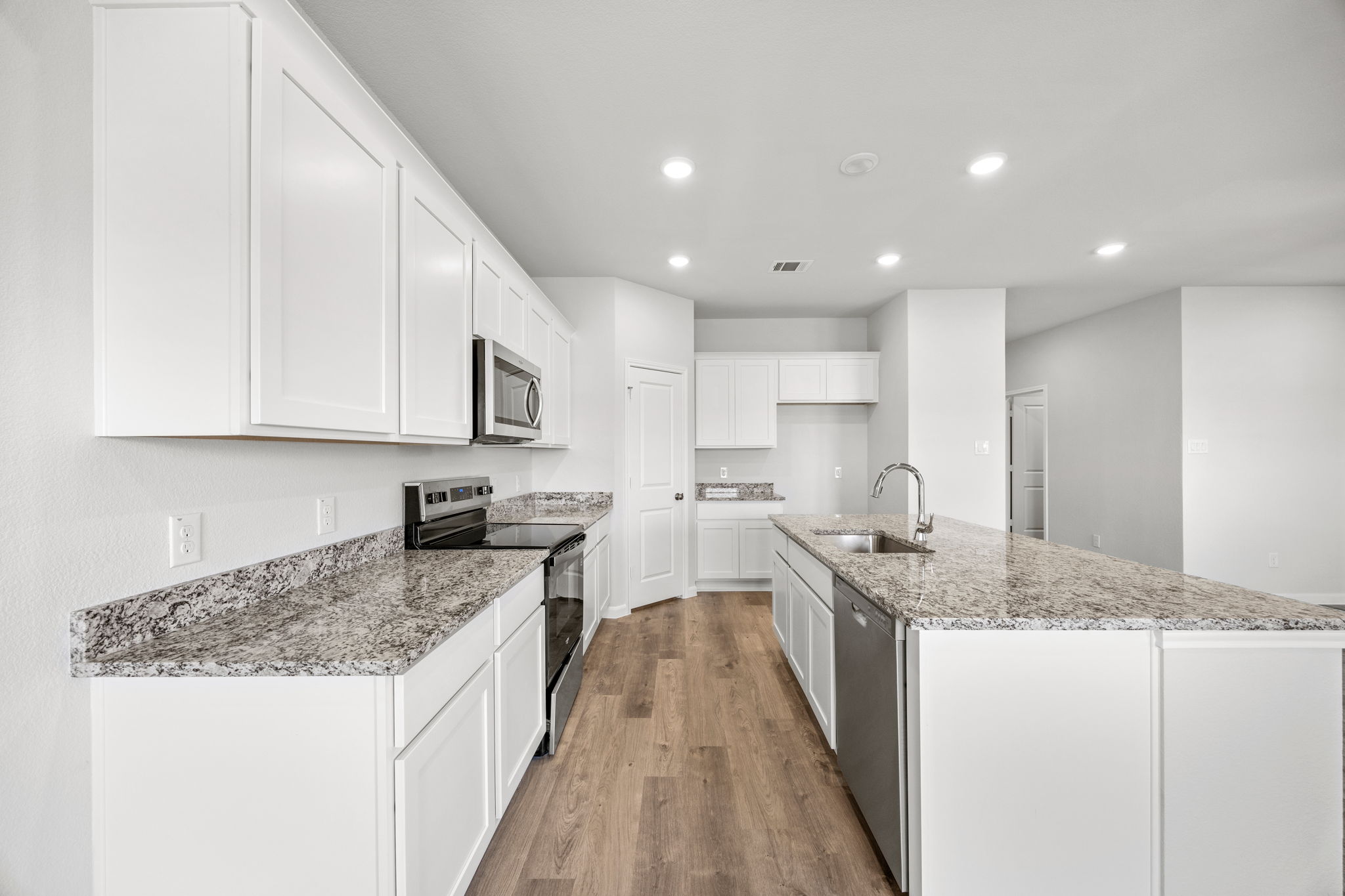 A kitchen with white cabinets.