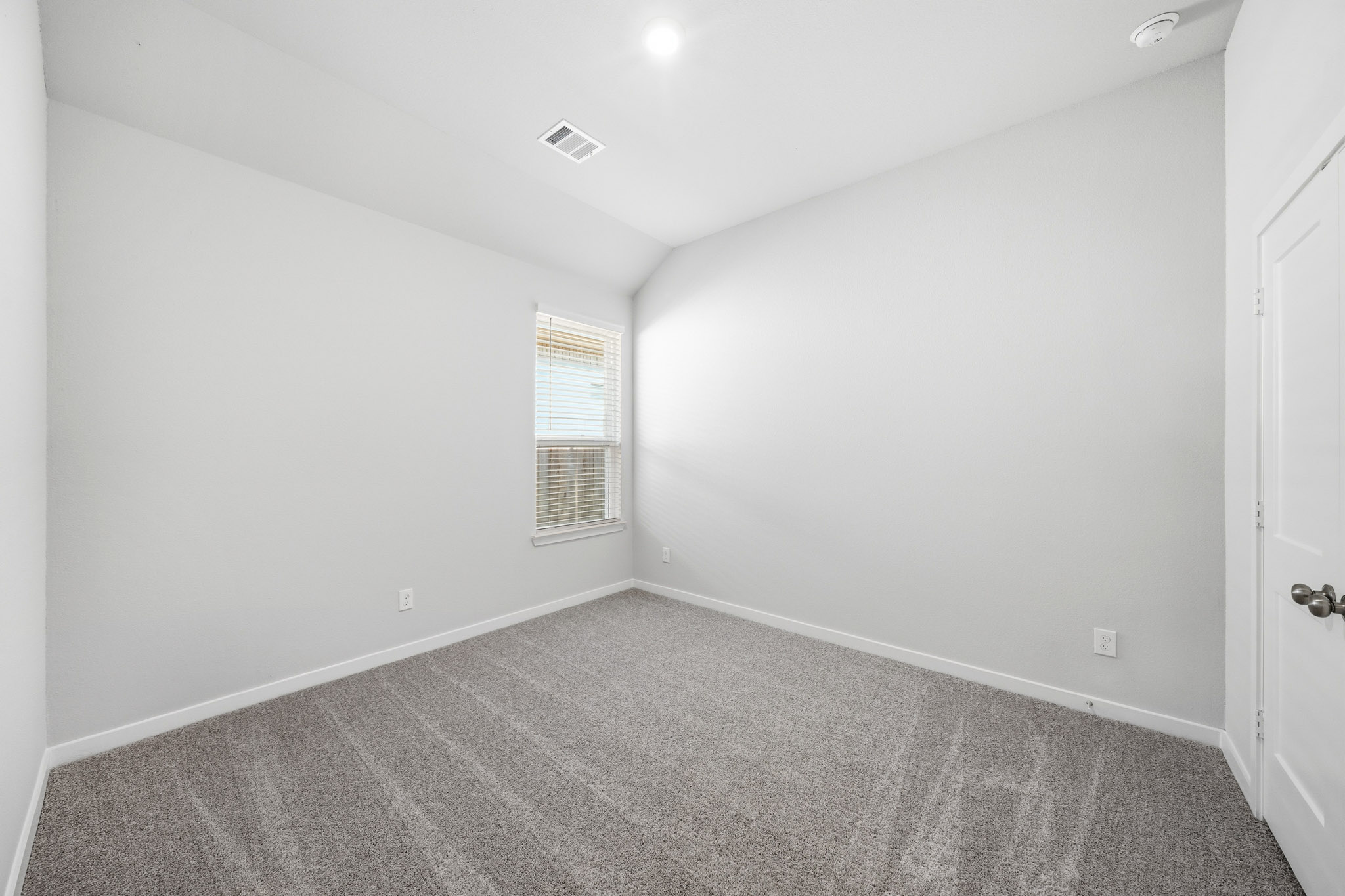A room with a carpet and a door.
