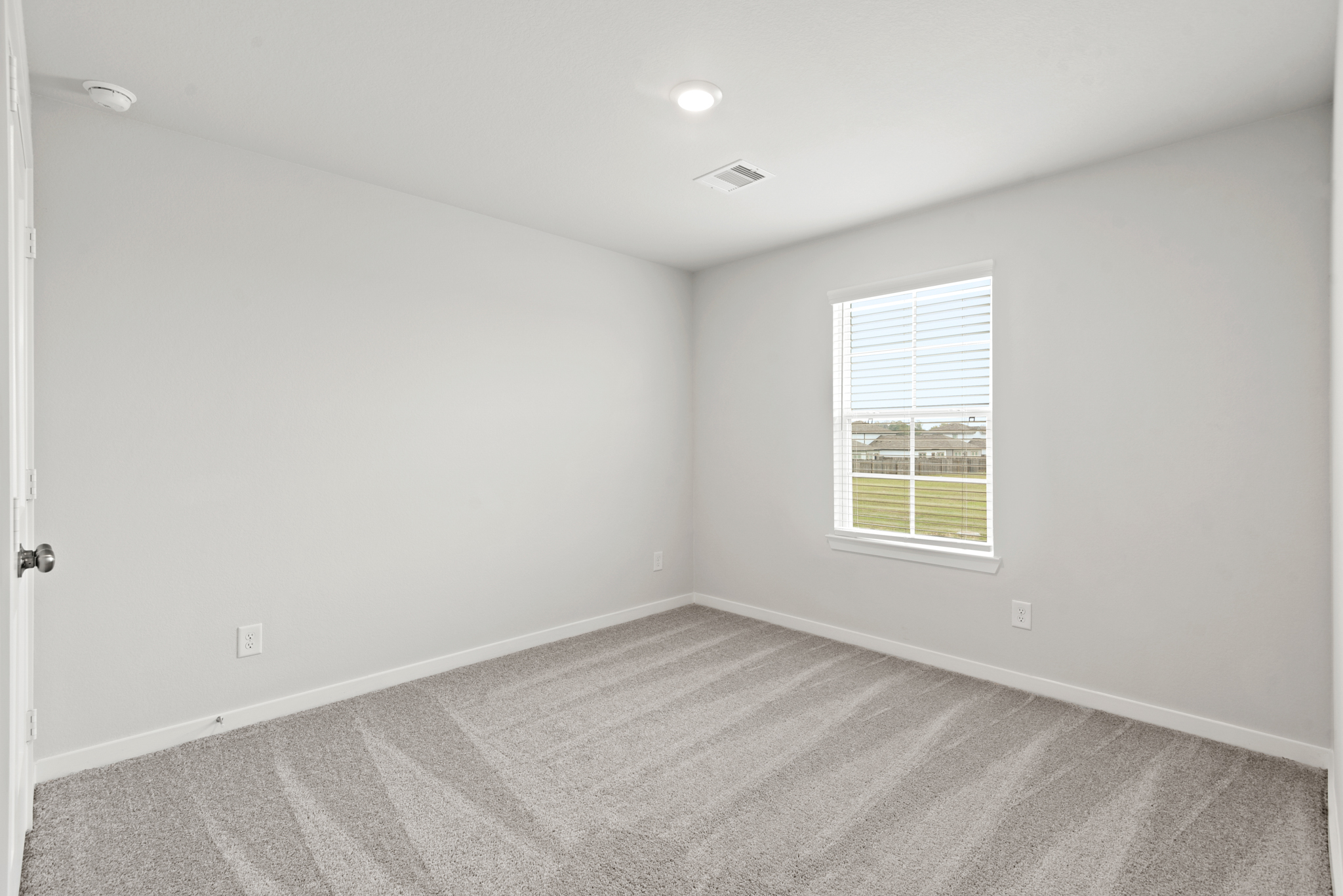 A room with a window and a carpet.