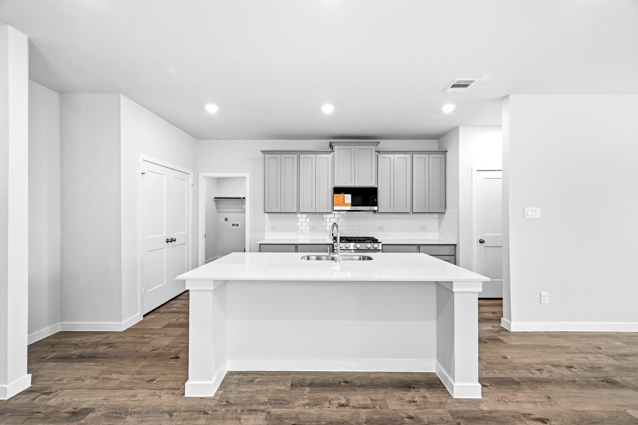 A large white kitchen with a white counter top.
