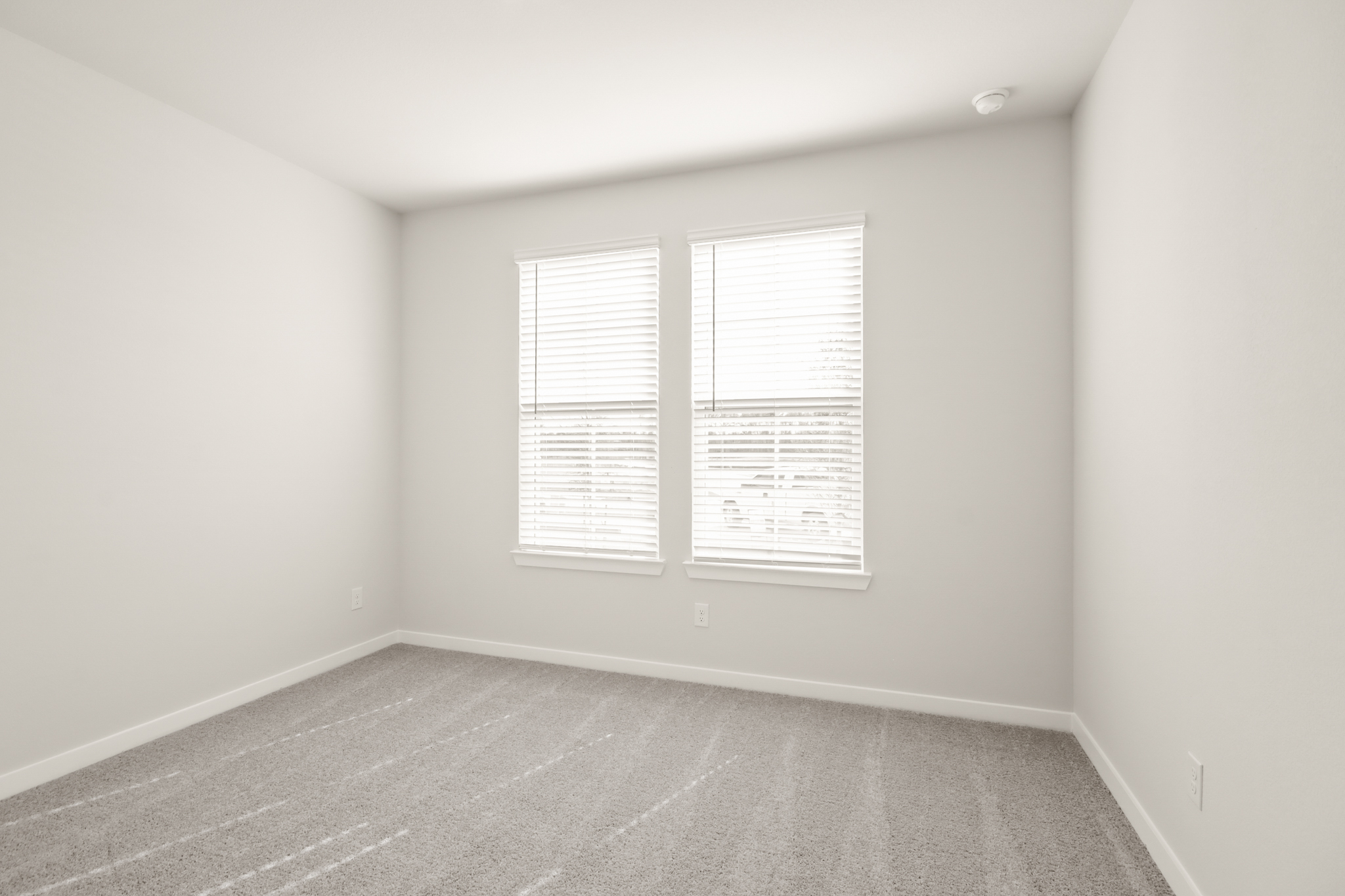 A room with a window and a rug.