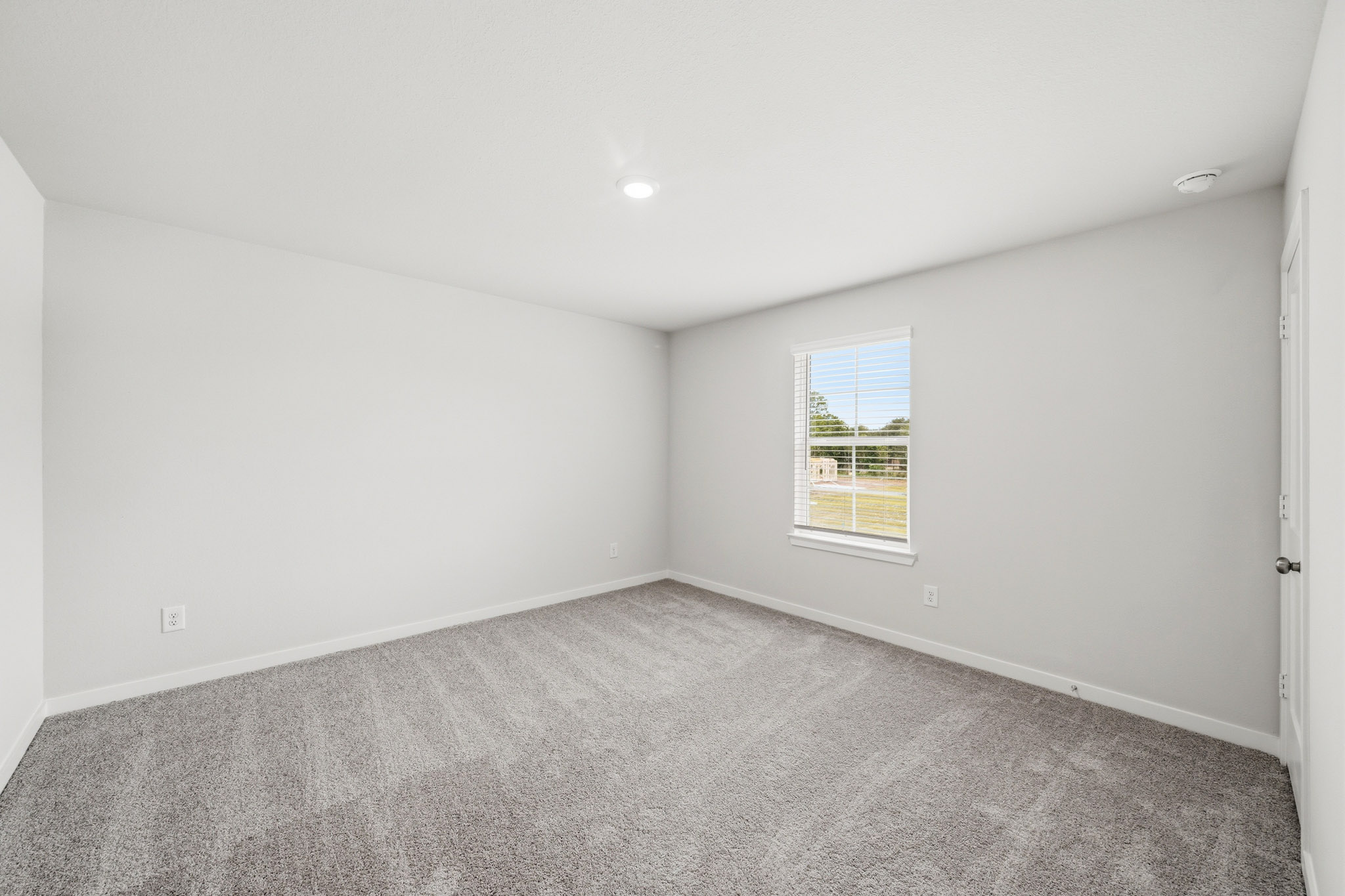 A room with a window and a carpet.