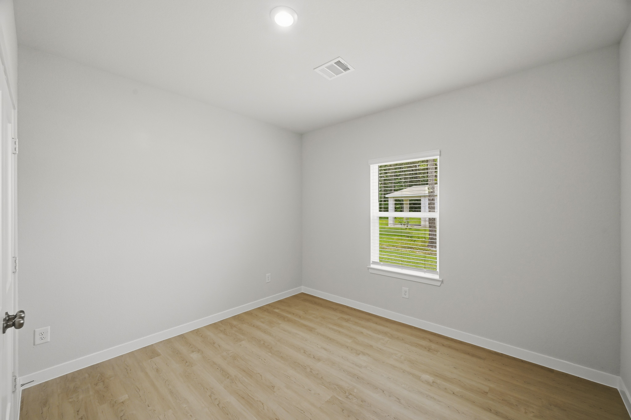A room with a wood floor and a window.
