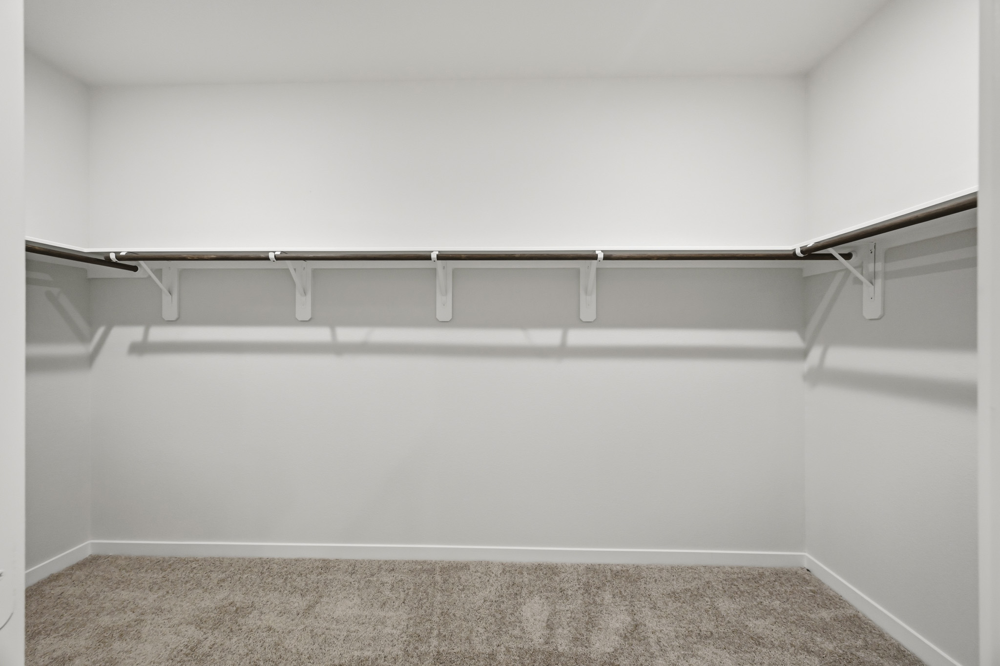 A white wall with a metal bar.