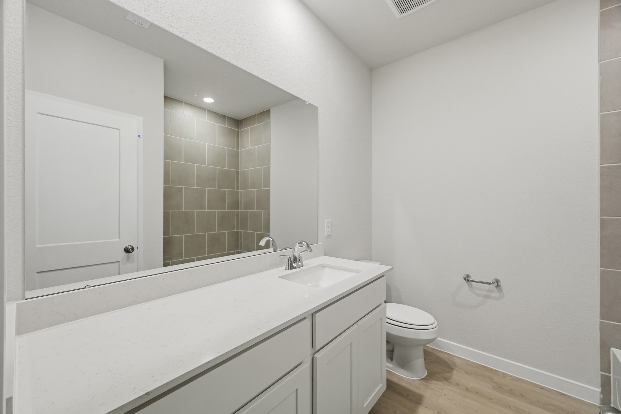A bathroom with a large mirror.