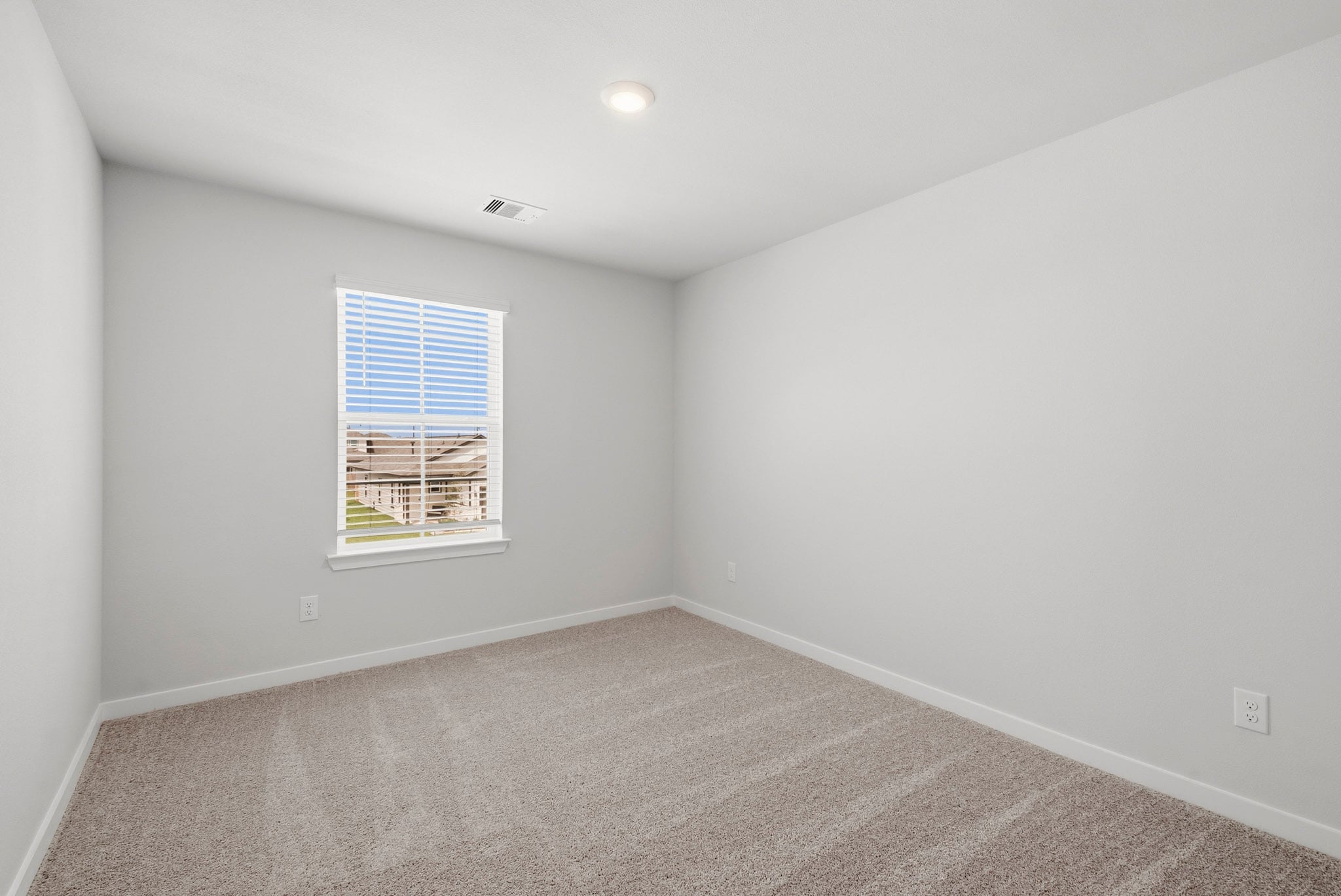 A room with a window and a carpet.