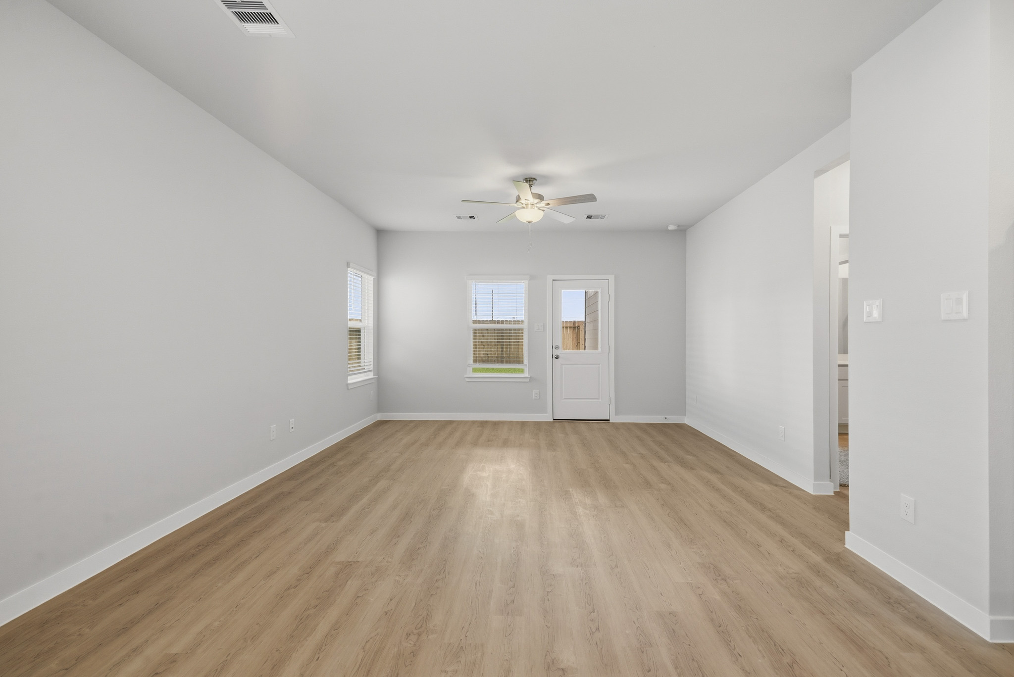 A room with a wood floor and a ceiling fan.