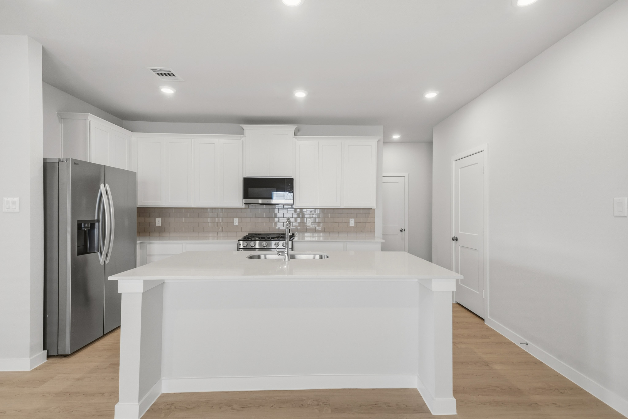 A kitchen with white cabinets.