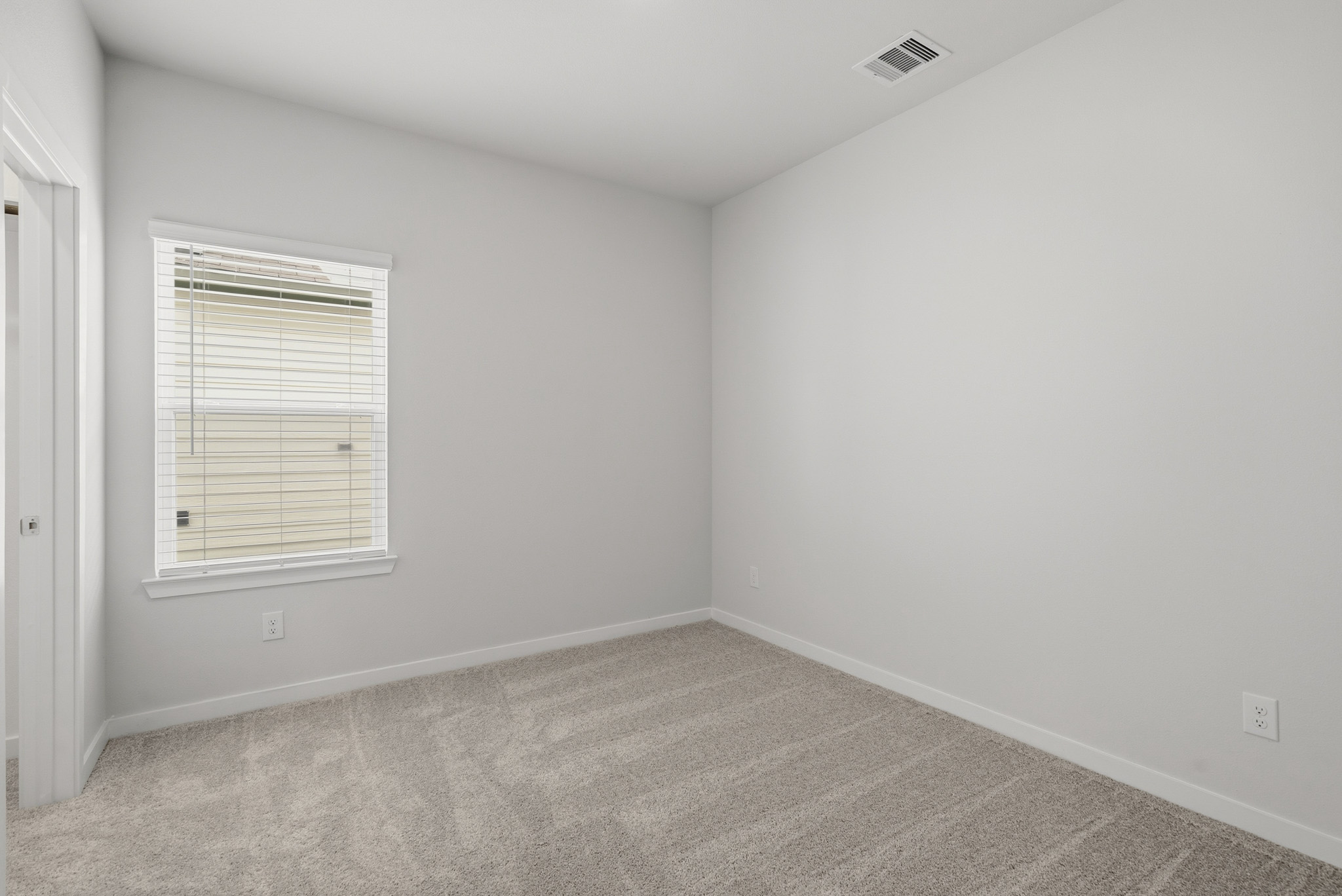 A room with a window and a carpet.