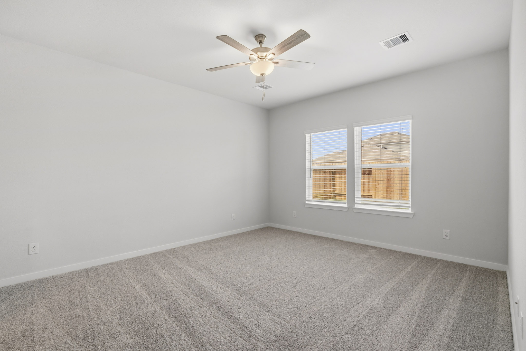 A room with a ceiling fan and a window.