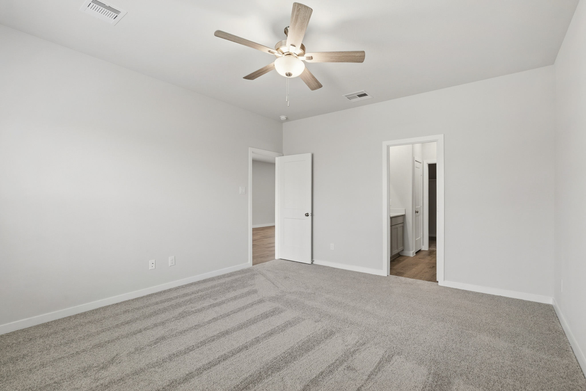 A room with a ceiling fan and a door.
