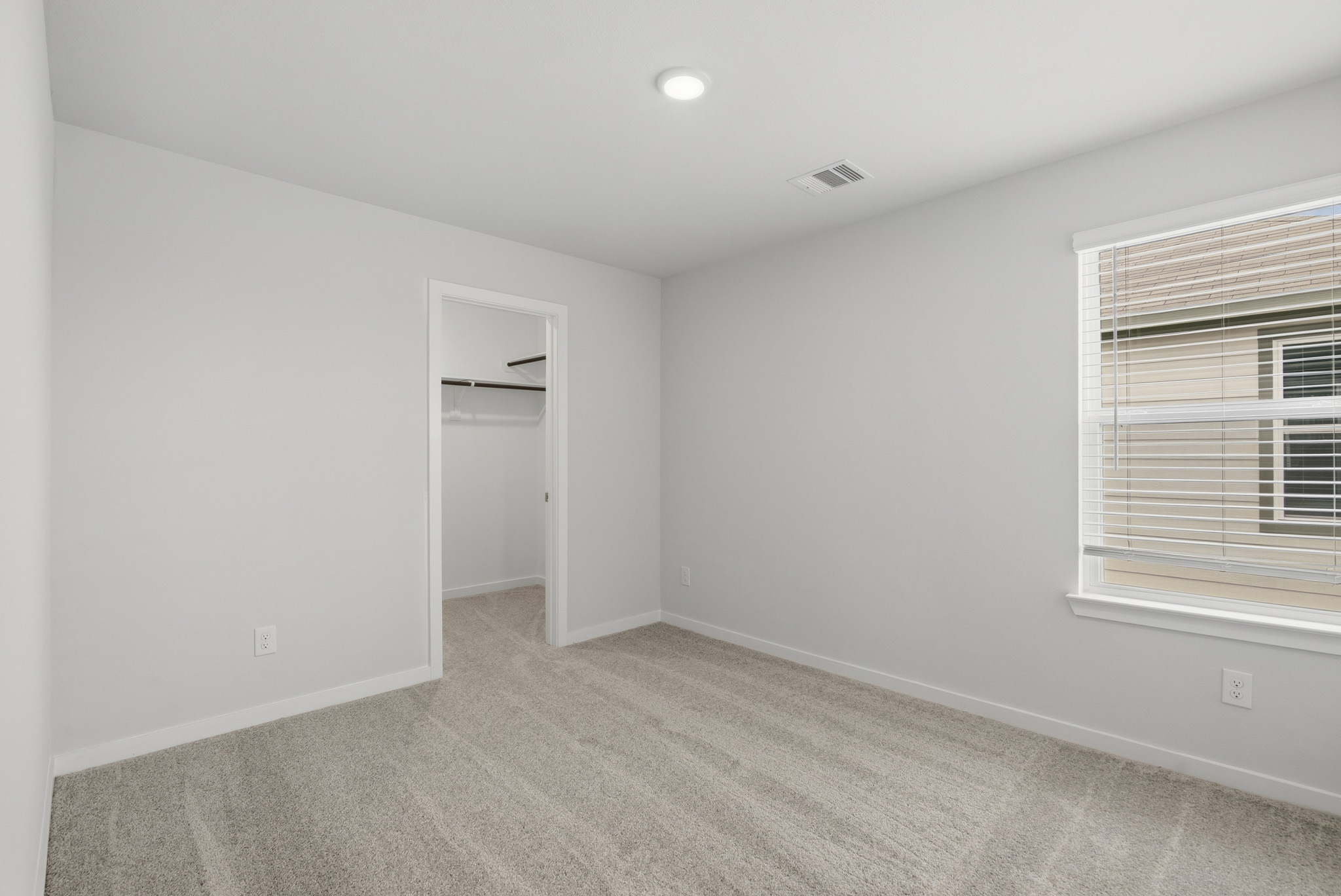 A room with a carpet and a window.