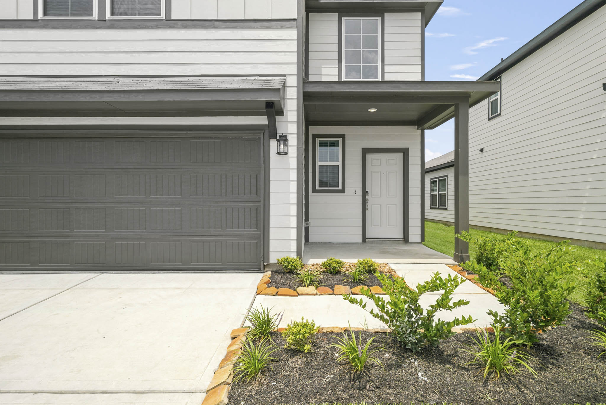 A house with garages and plants.