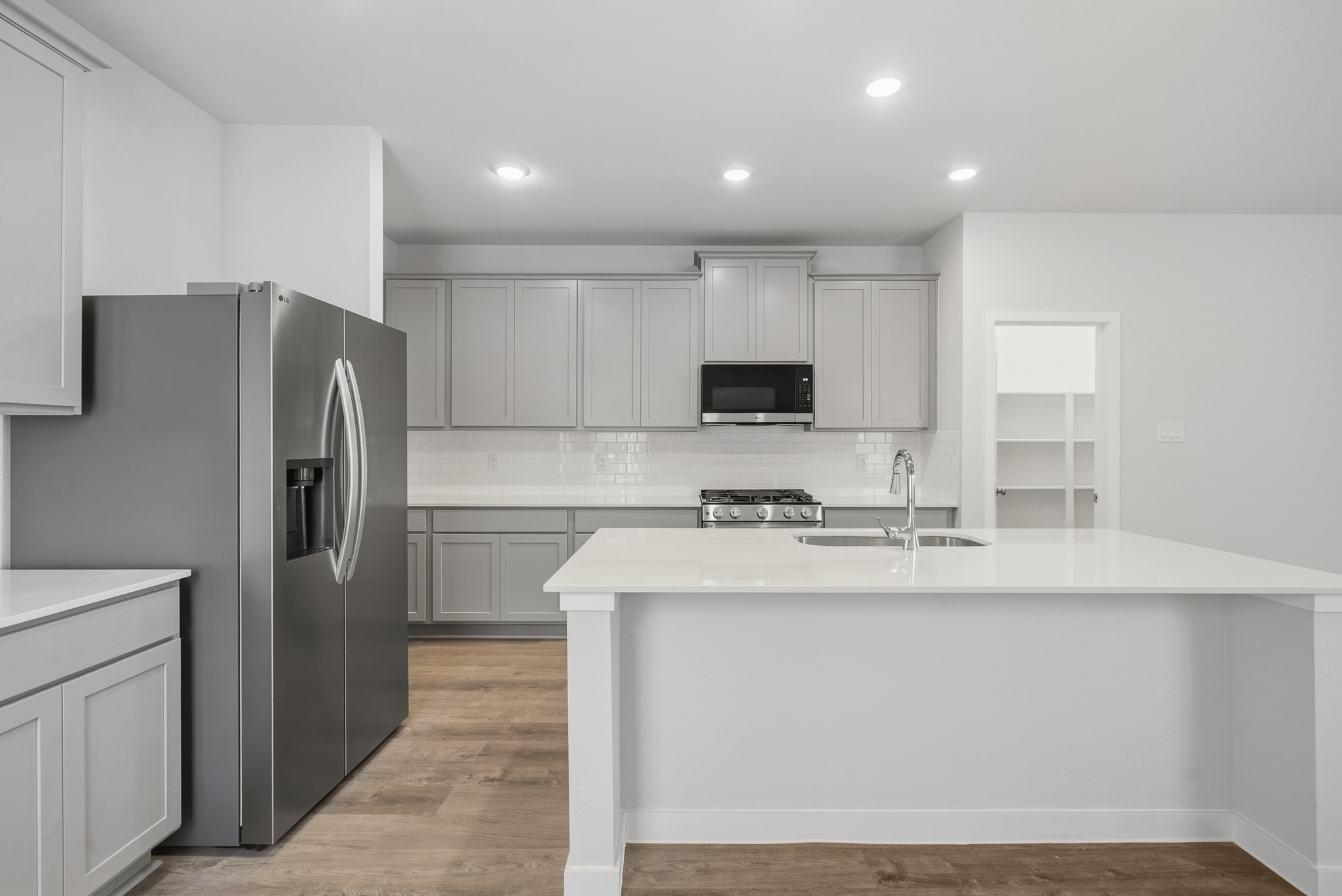 A kitchen with white cabinets.
