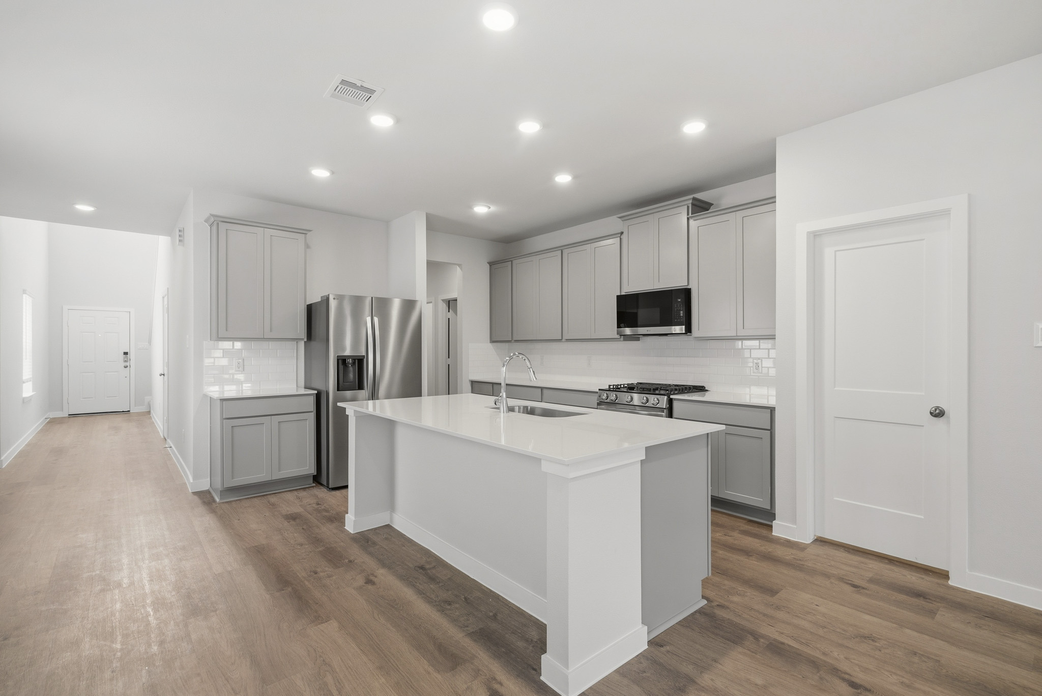 A kitchen with white cabinets.