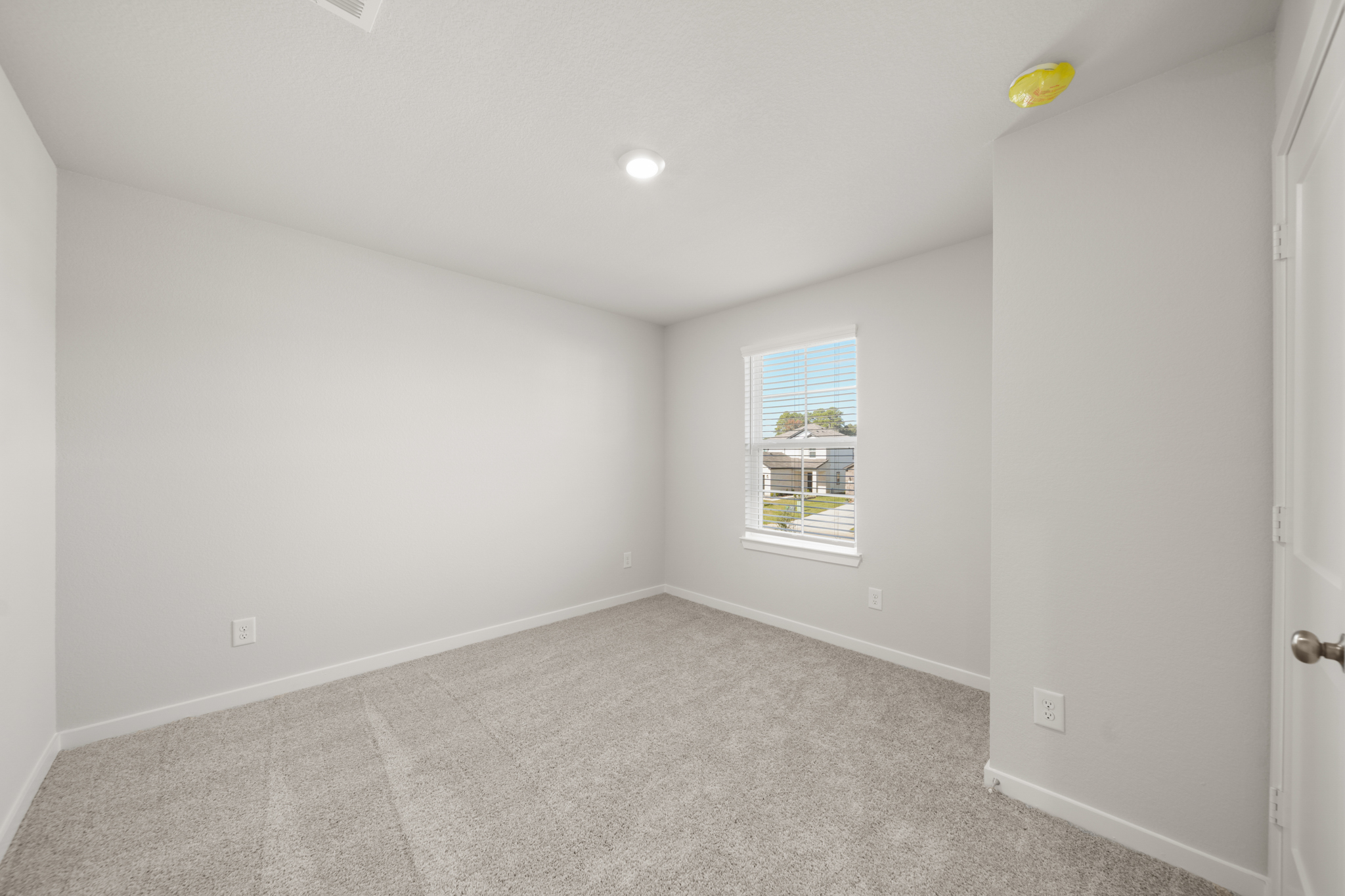 A room with a carpet and a window.