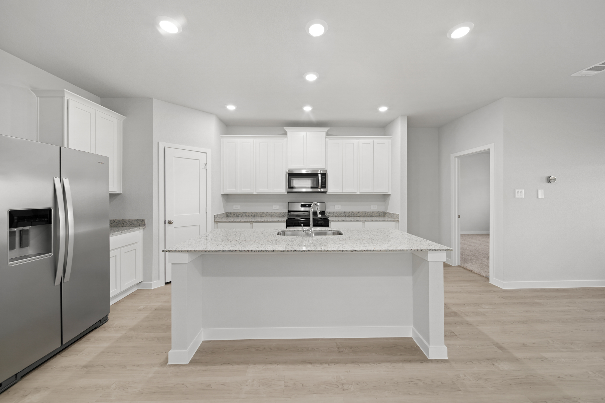 A kitchen with white cabinets.
