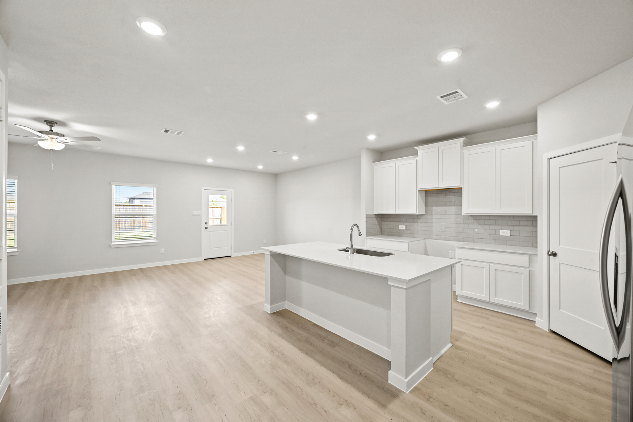 A kitchen with white cabinets.