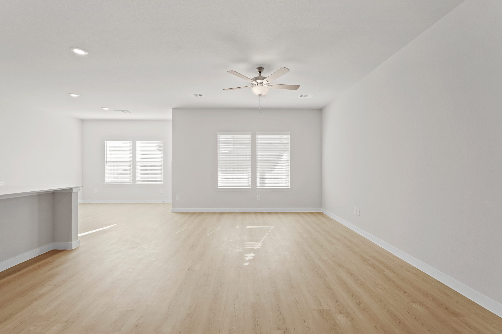 A room with a wood floor and a ceiling fan.