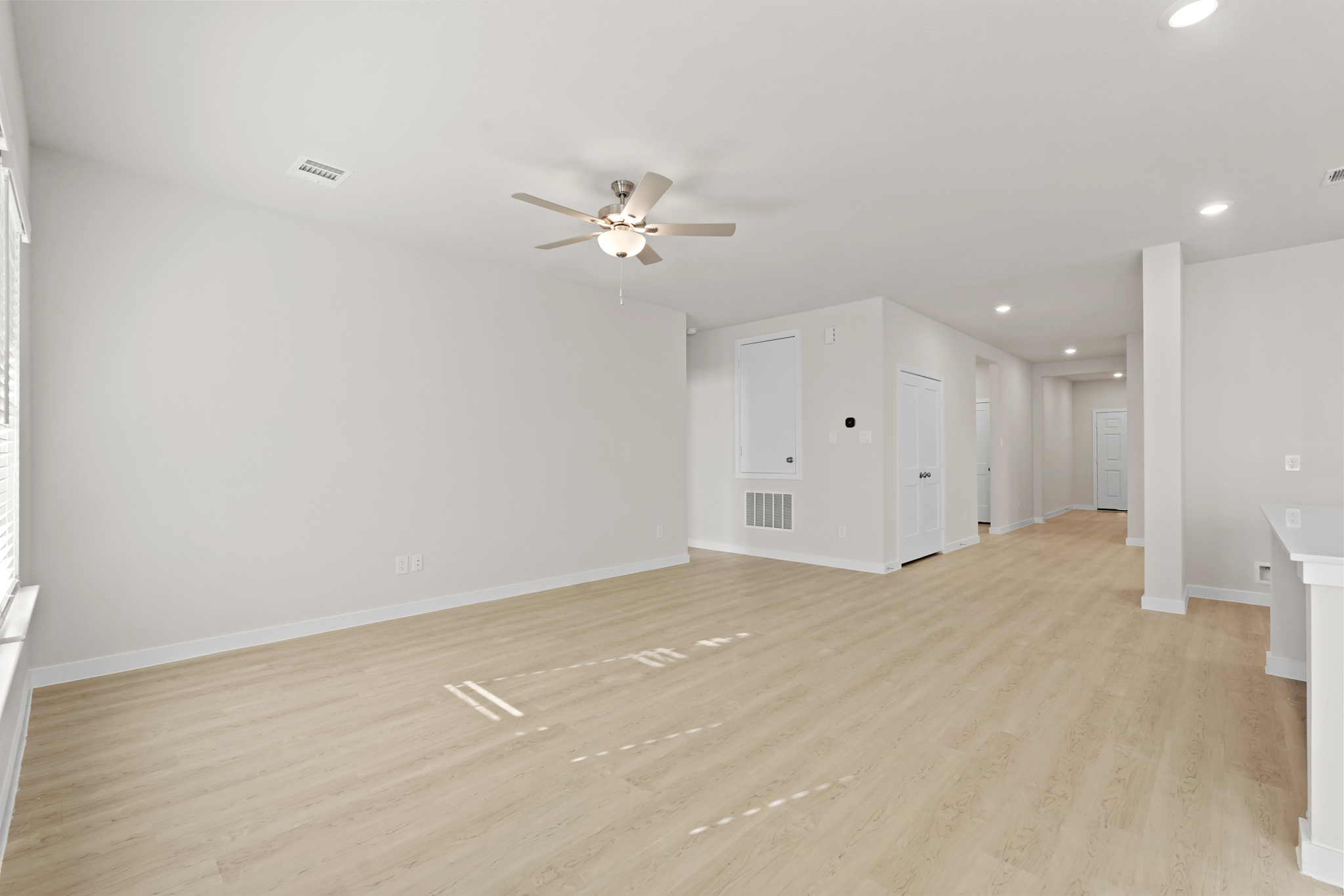 A room with a wood floor and a ceiling fan.