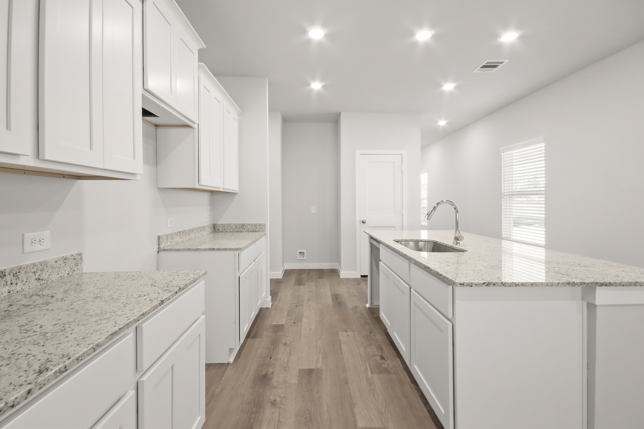 A kitchen with white cabinets.
