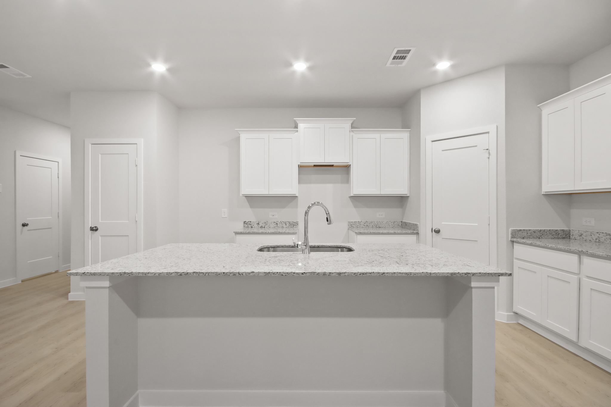 A kitchen with white cabinets.