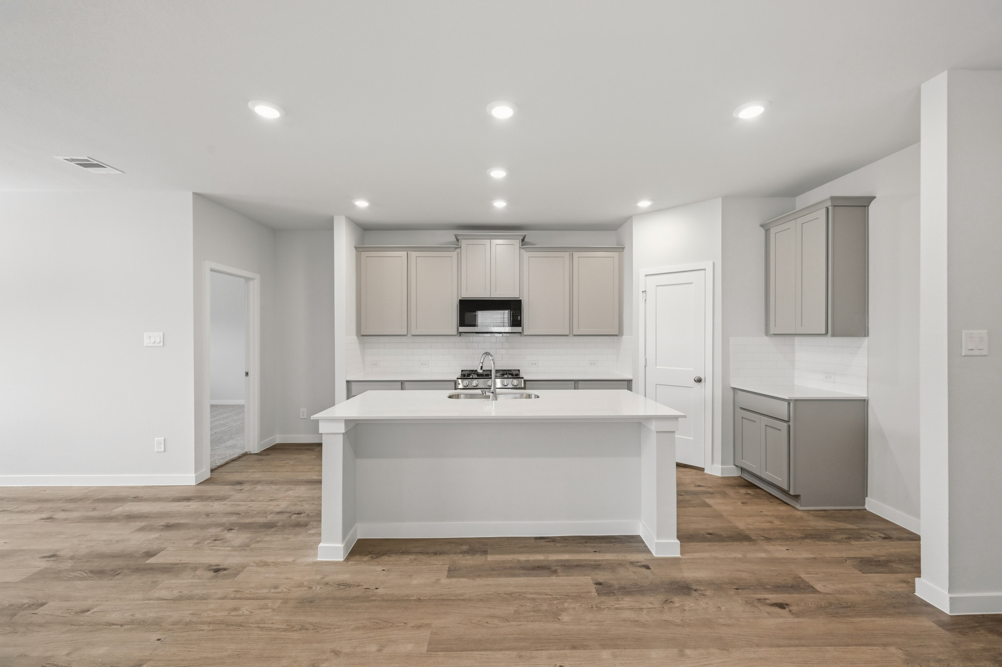 A kitchen with white cabinets.