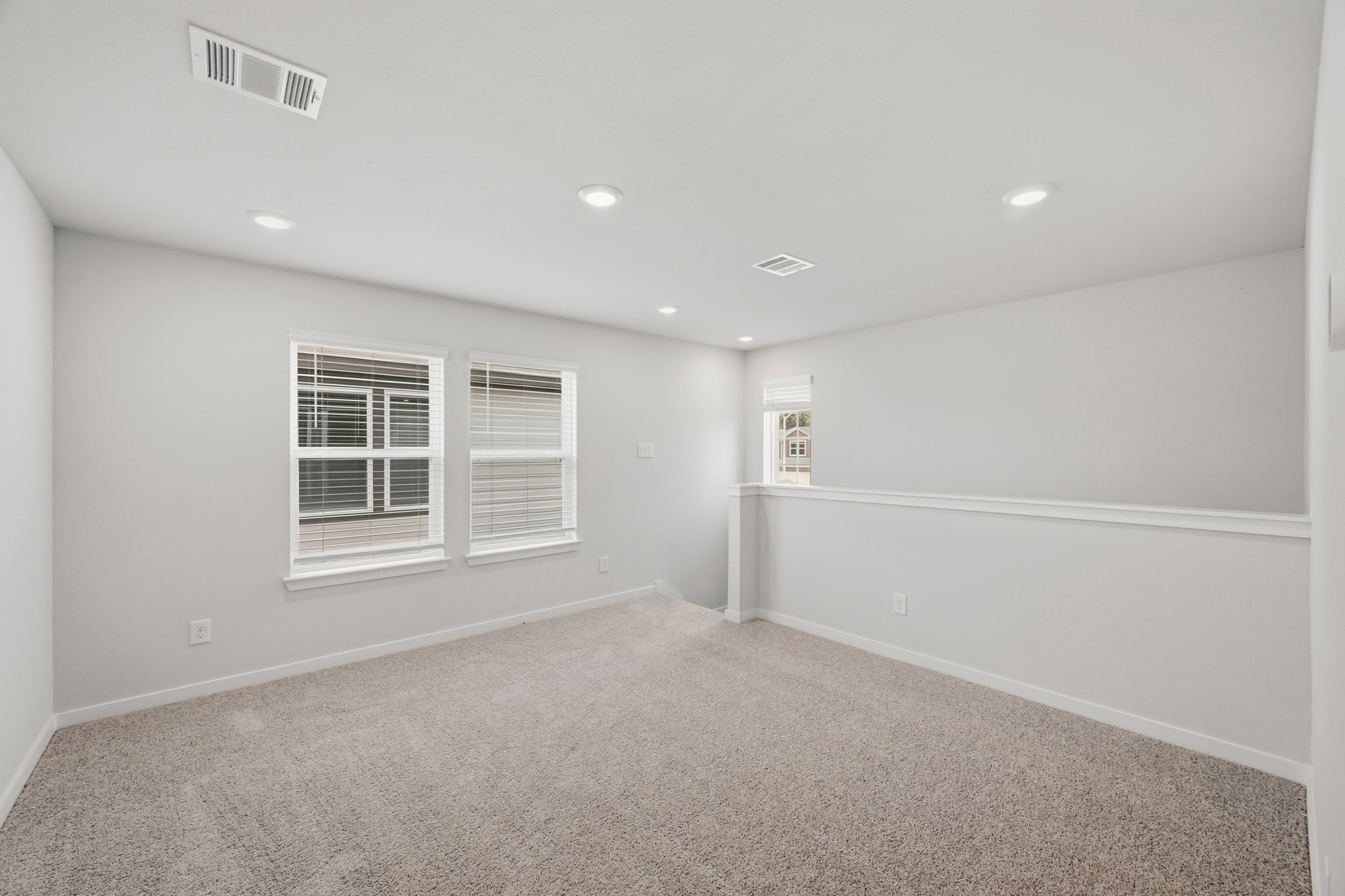 A room with a white wall and a window.