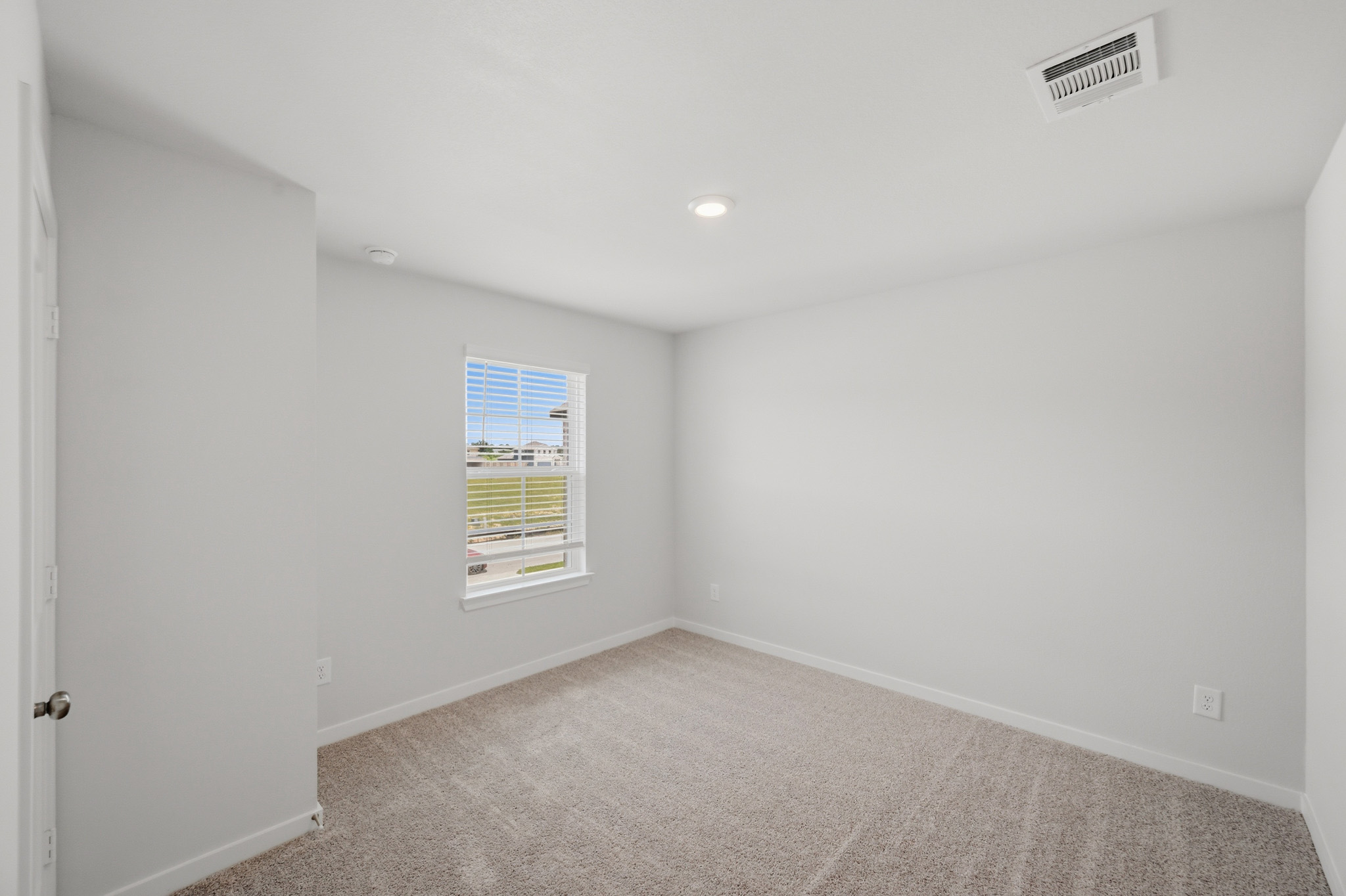 A room with a carpet and a window.