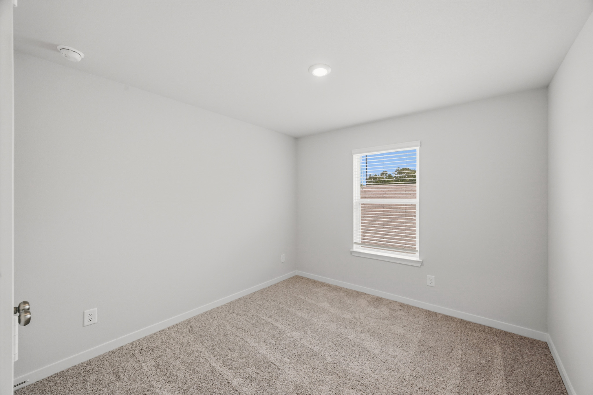 A room with a carpet and a window.