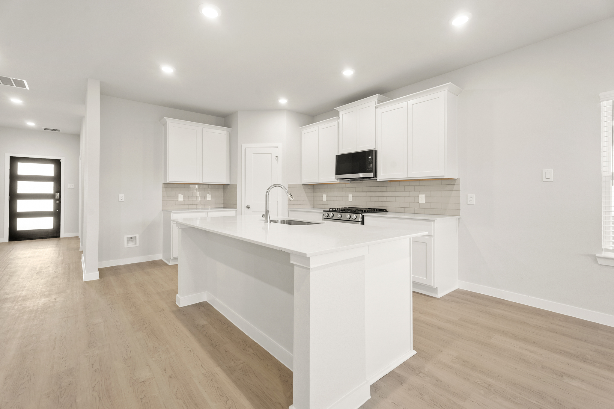 A kitchen with white cabinets.