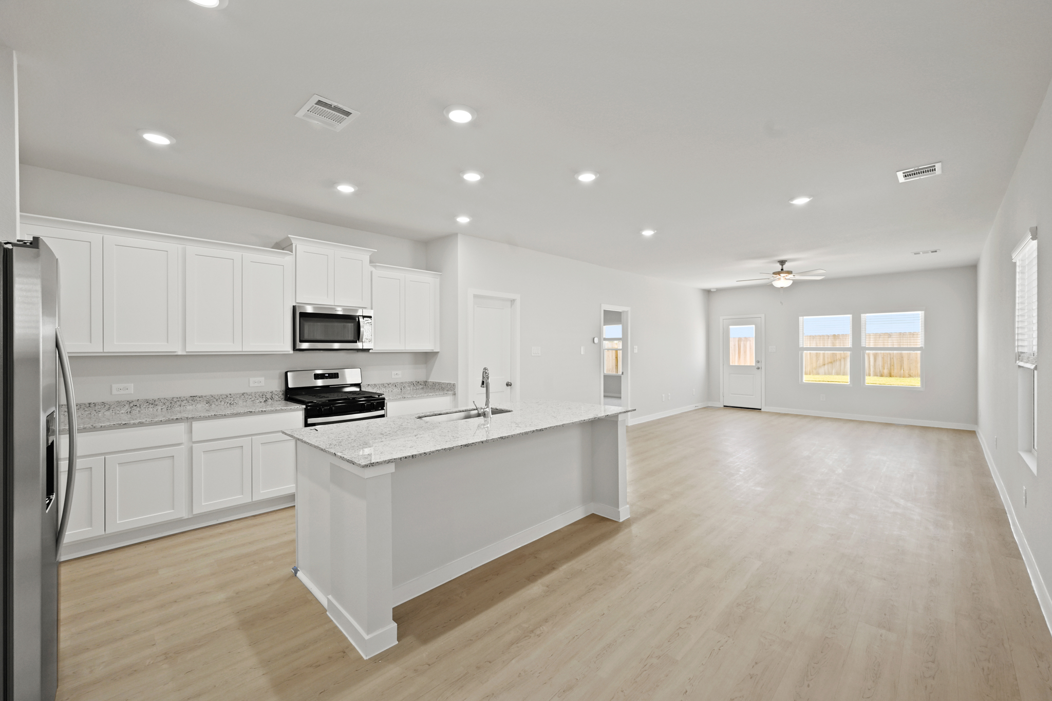 A kitchen with white cabinets.