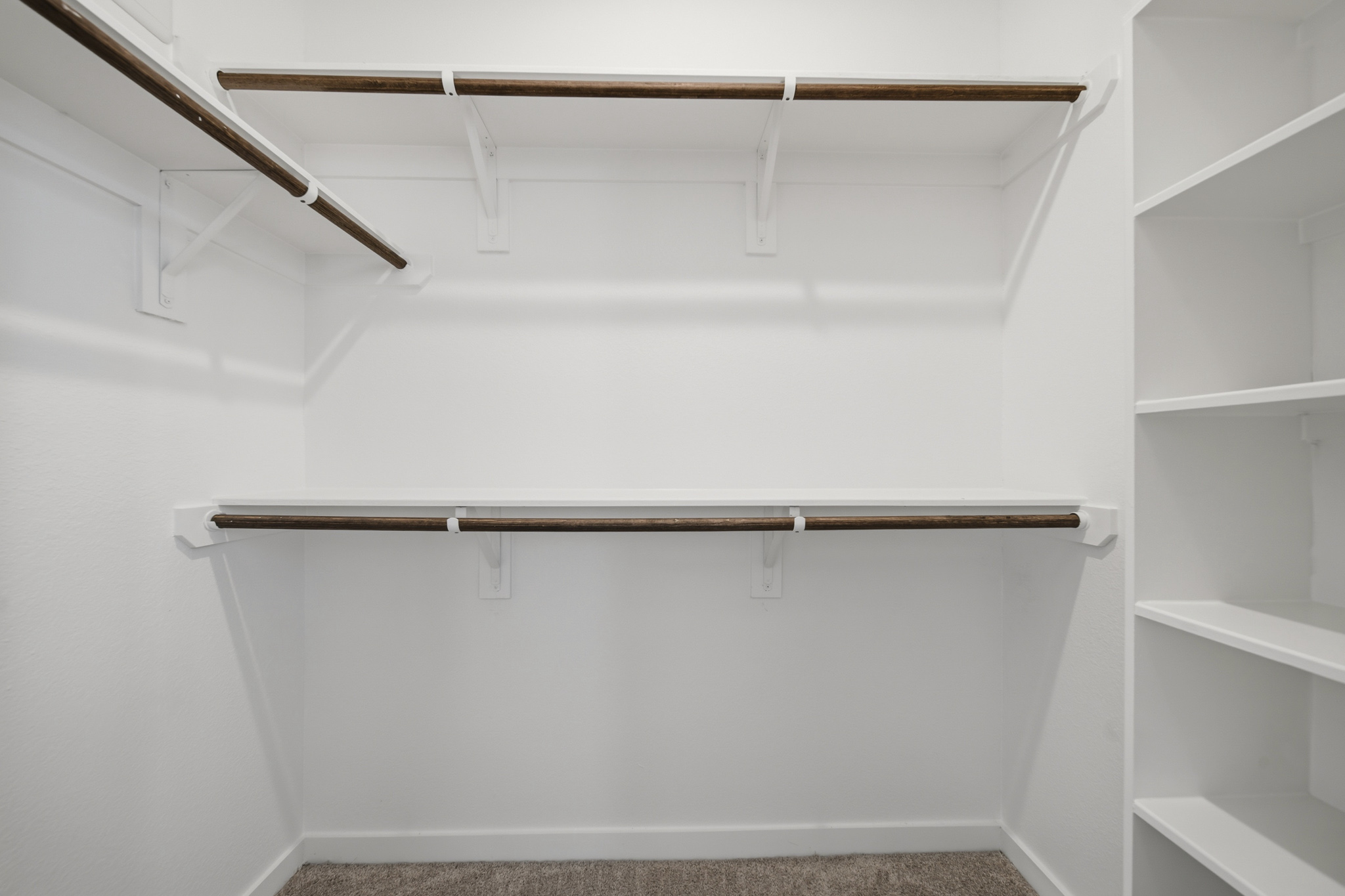 A white wall with a metal bar.