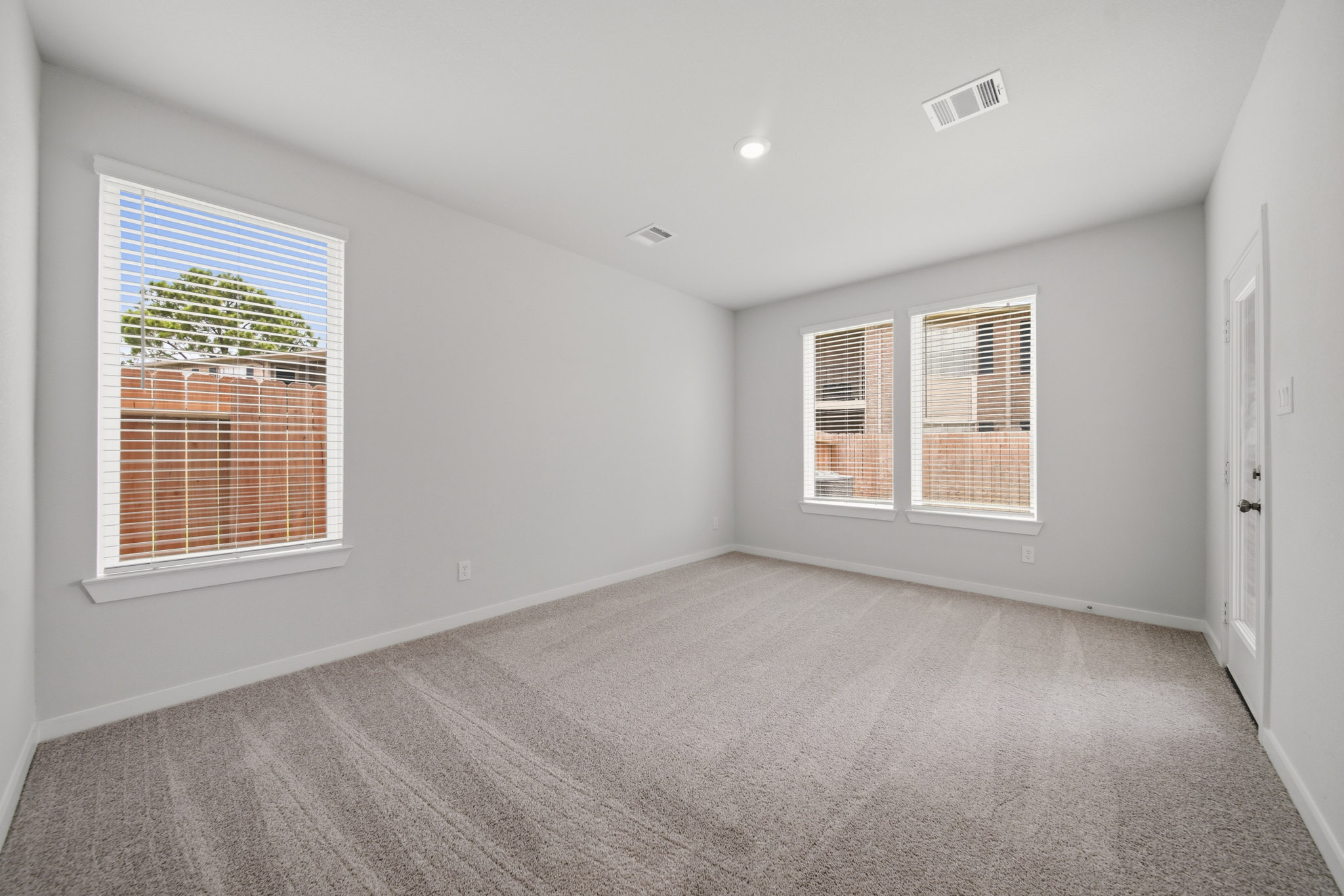 A room with a carpet and windows.