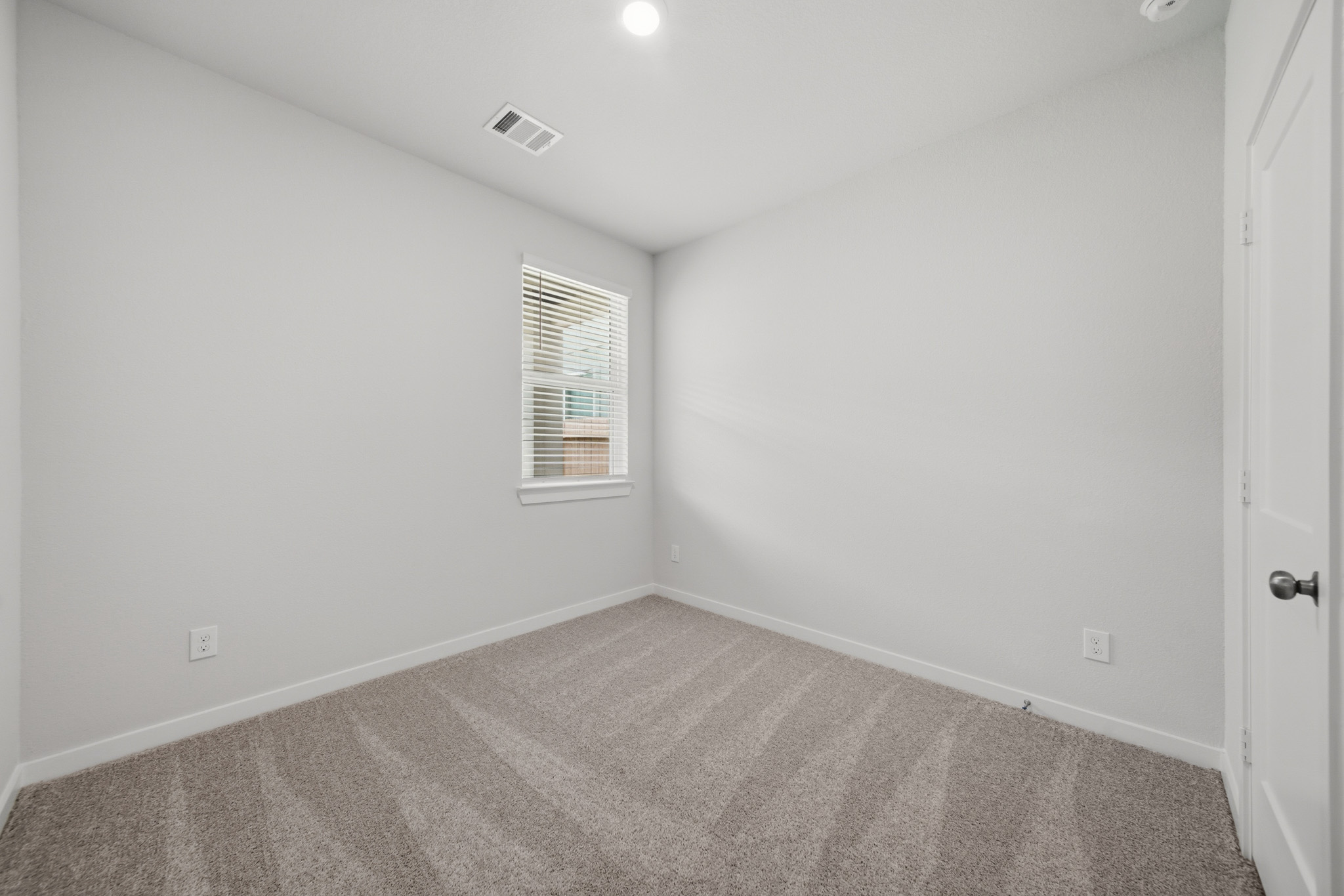 A room with a carpet and a window.