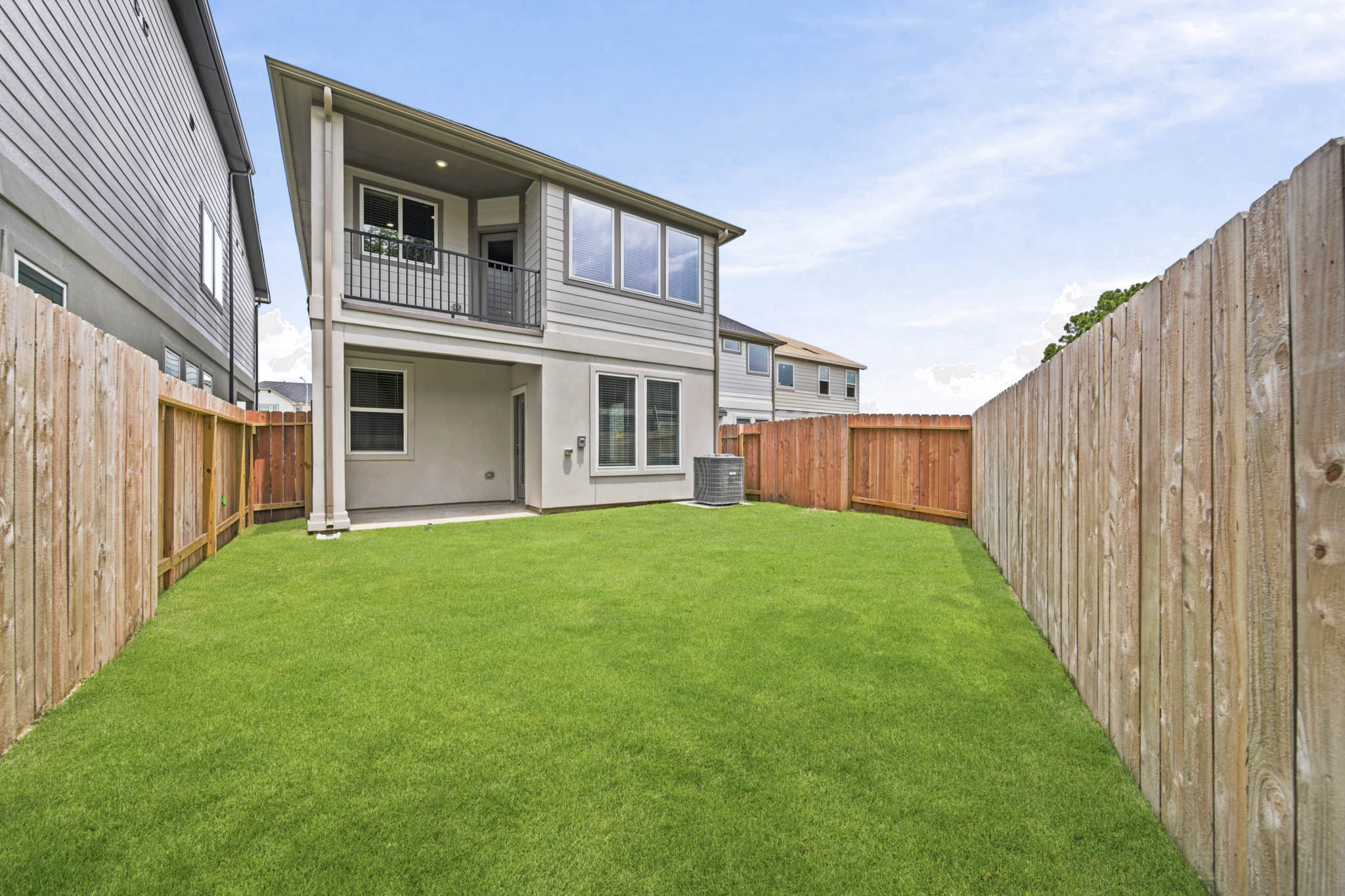 A backyard with a fence and a house.