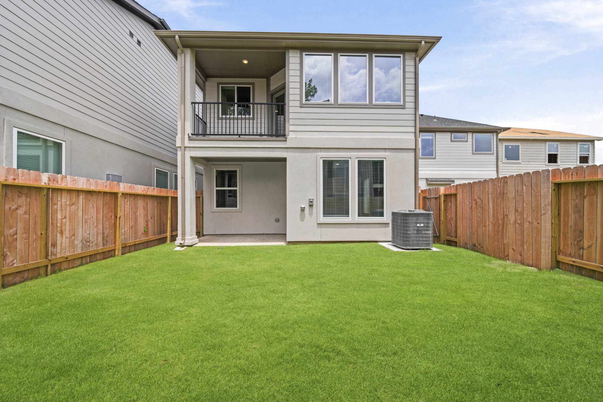 A house with a fence and a green lawn.