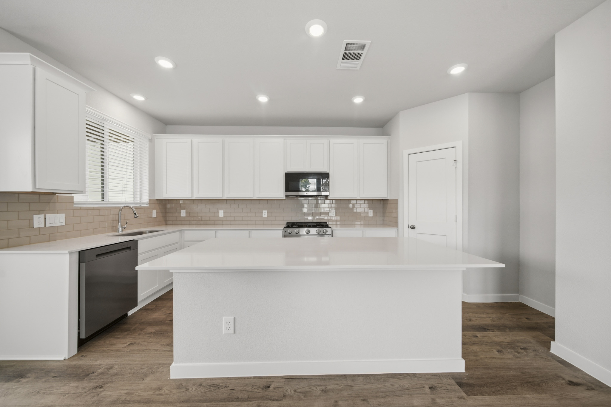A kitchen with white cabinets.