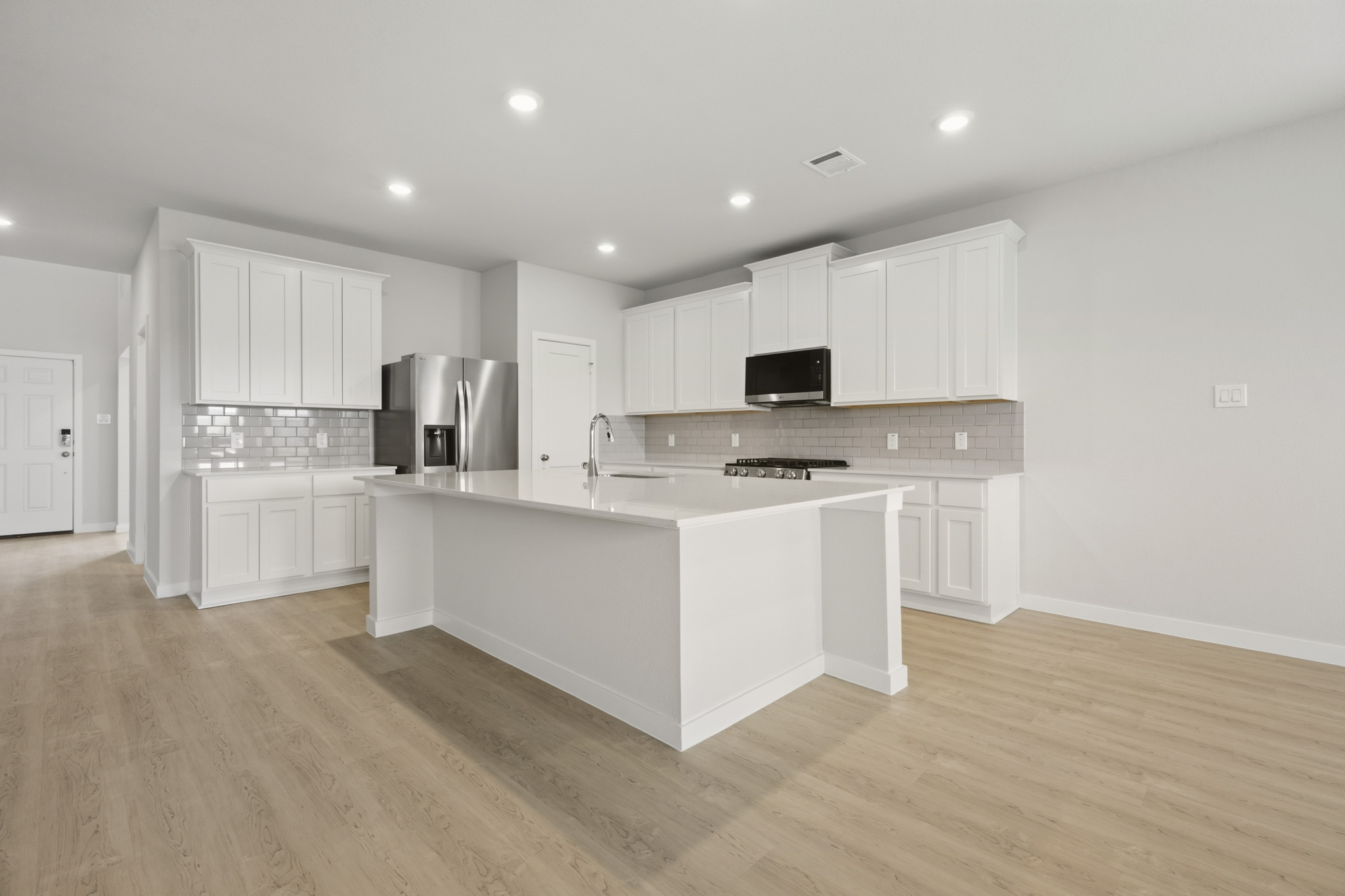 A kitchen with white cabinets.