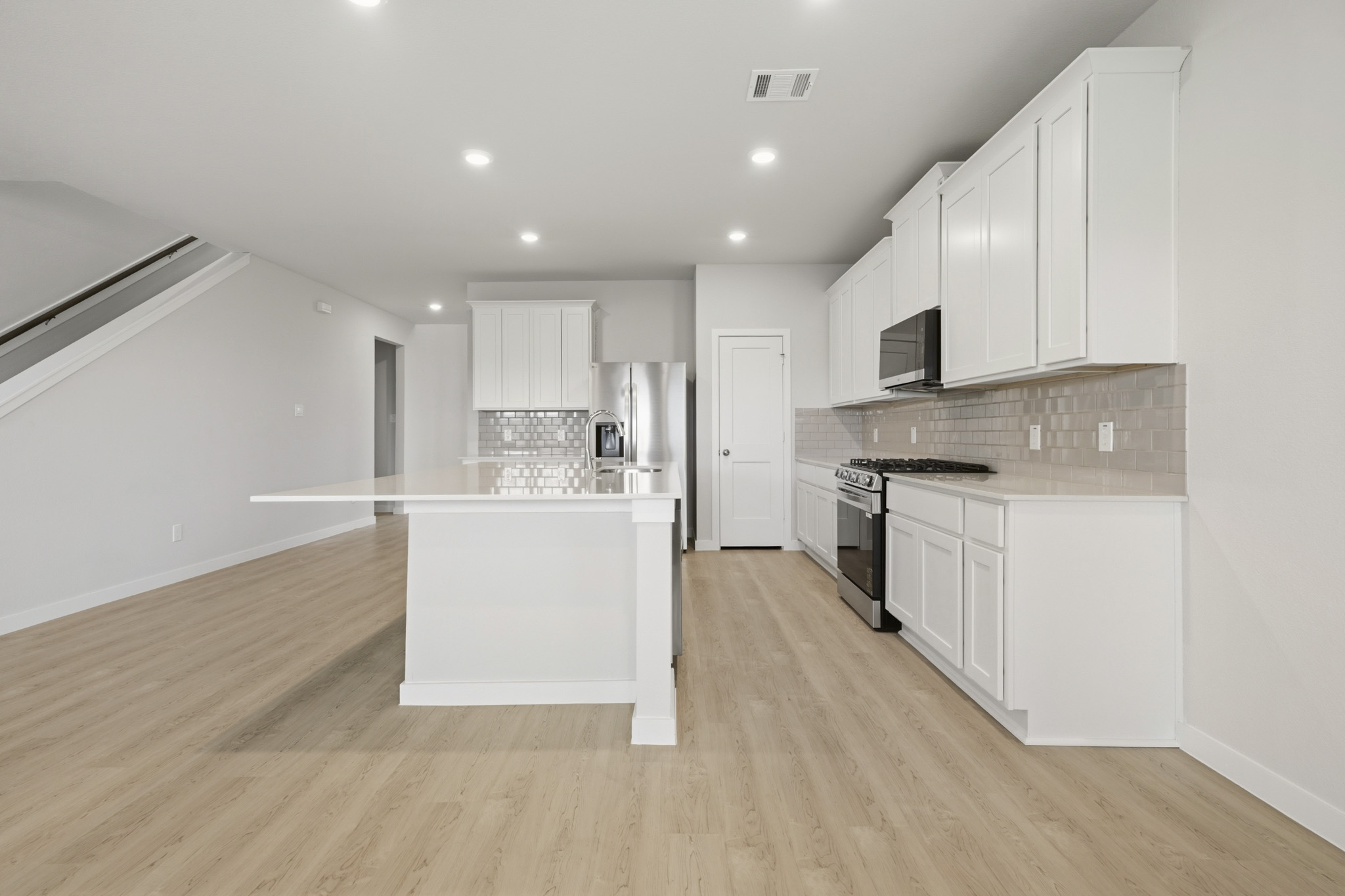 A kitchen with white cabinets.