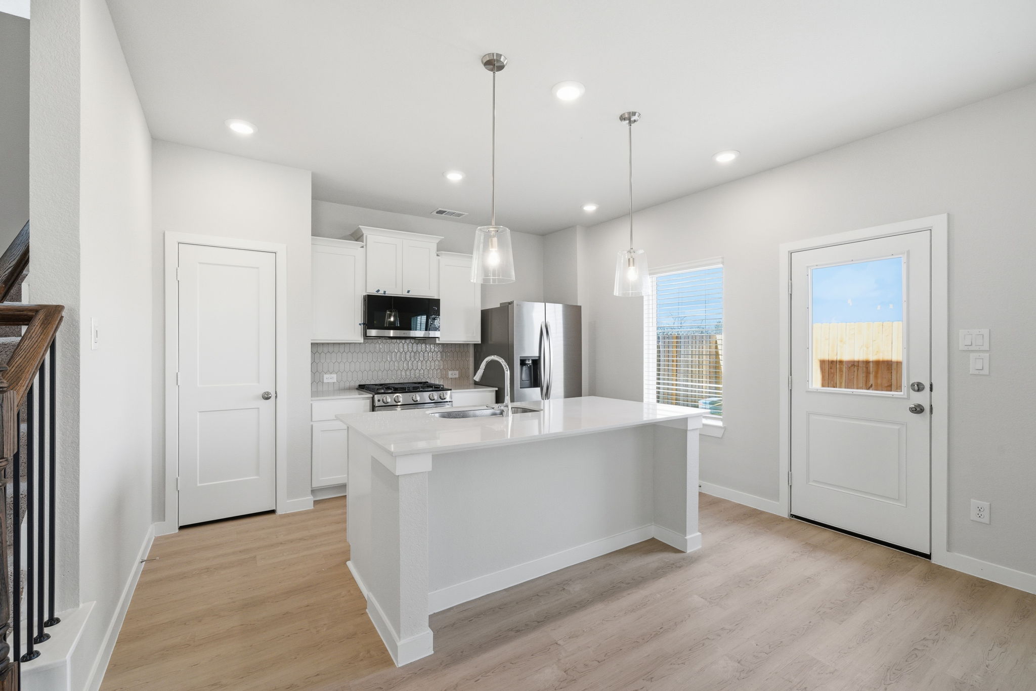 A kitchen with white cabinets.