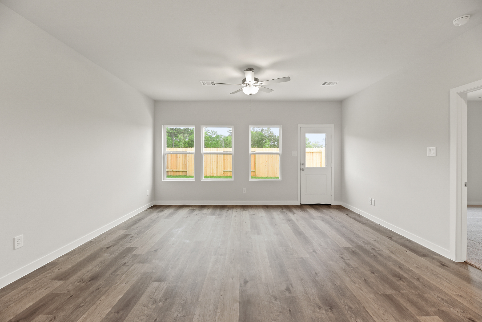A room with a wood floor and a ceiling fan.