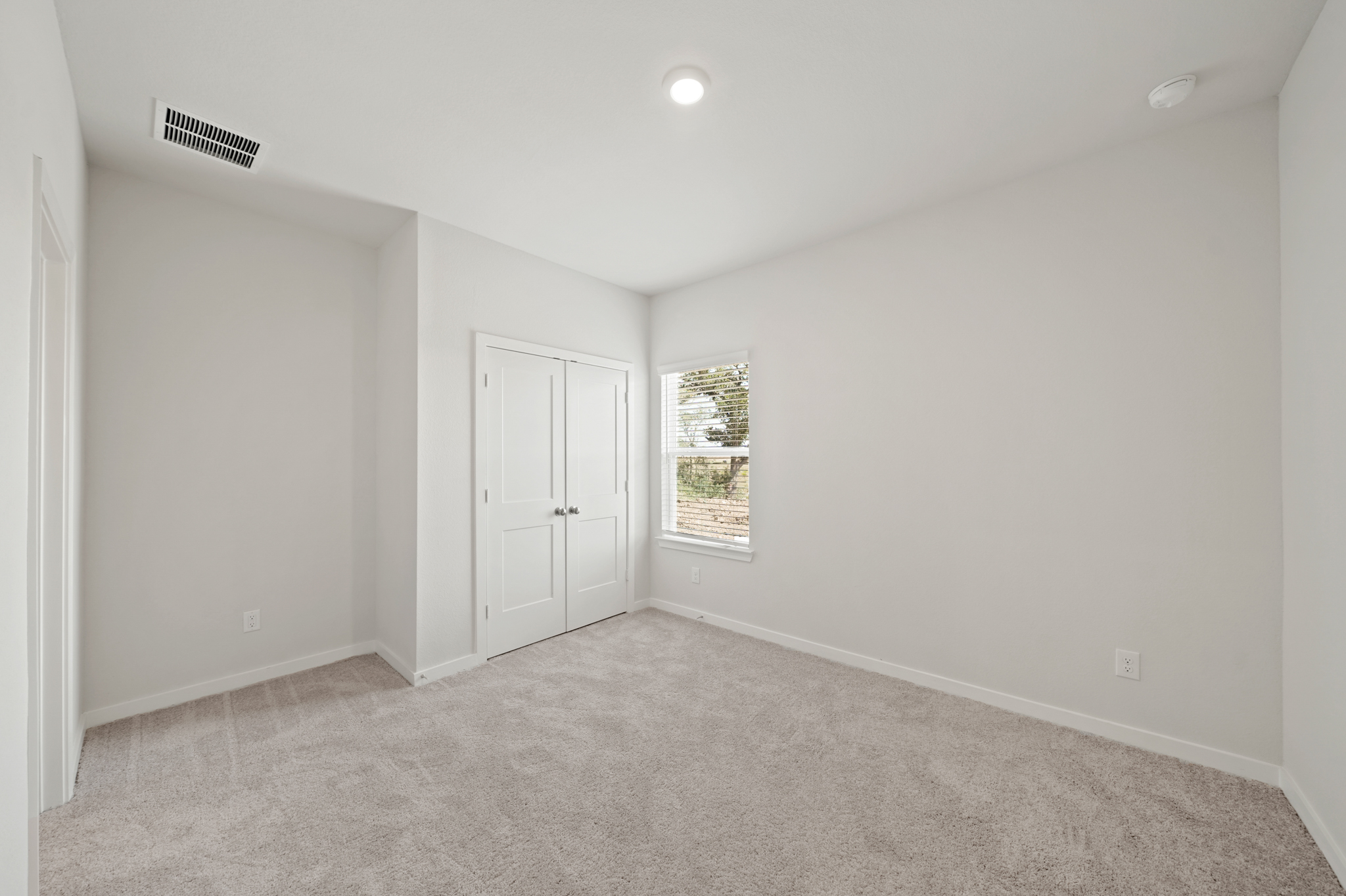 A room with white walls and a window.