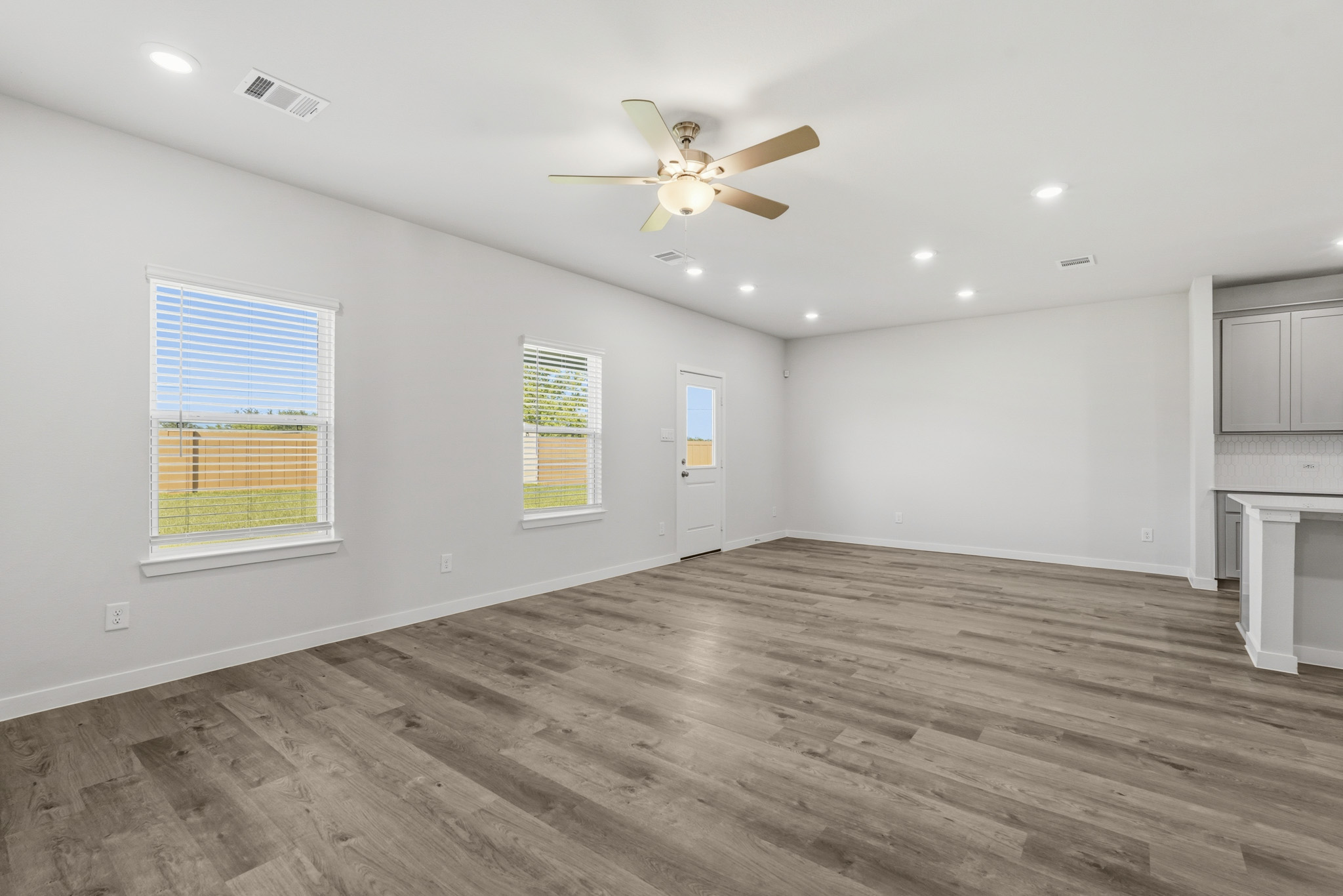 A room with a wood floor and a ceiling fan.